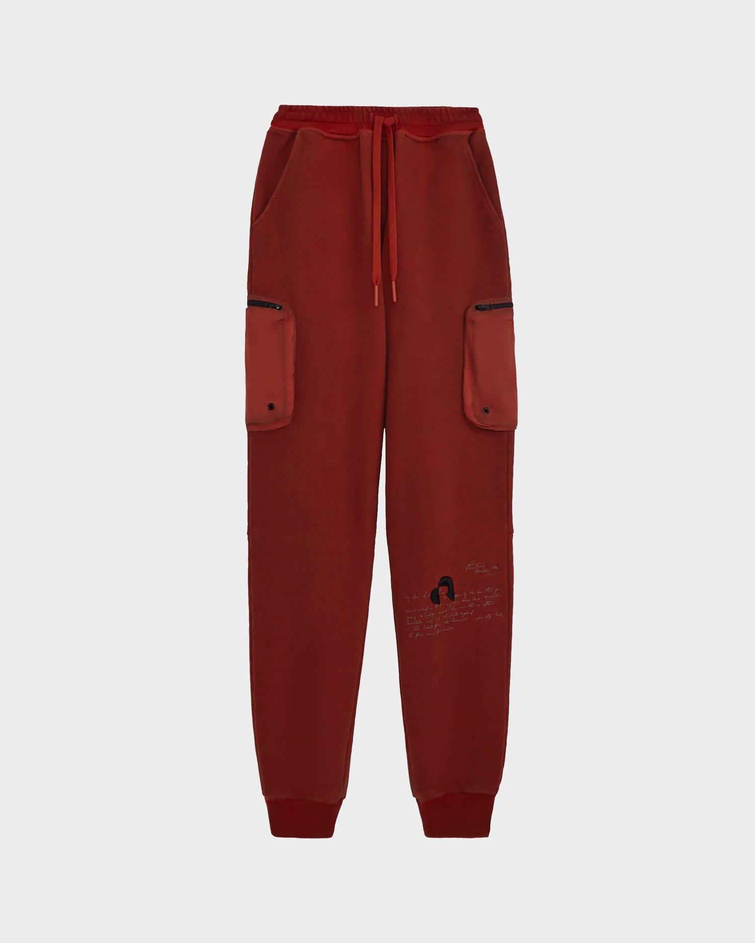 The MILANO - 9523509 joggers by Rudsak in orange (M) feature an elastic waistband, drawstring, recycled nylon zip cargo pockets, and a small black sketch with text on the left leg—combining style and sustainability.