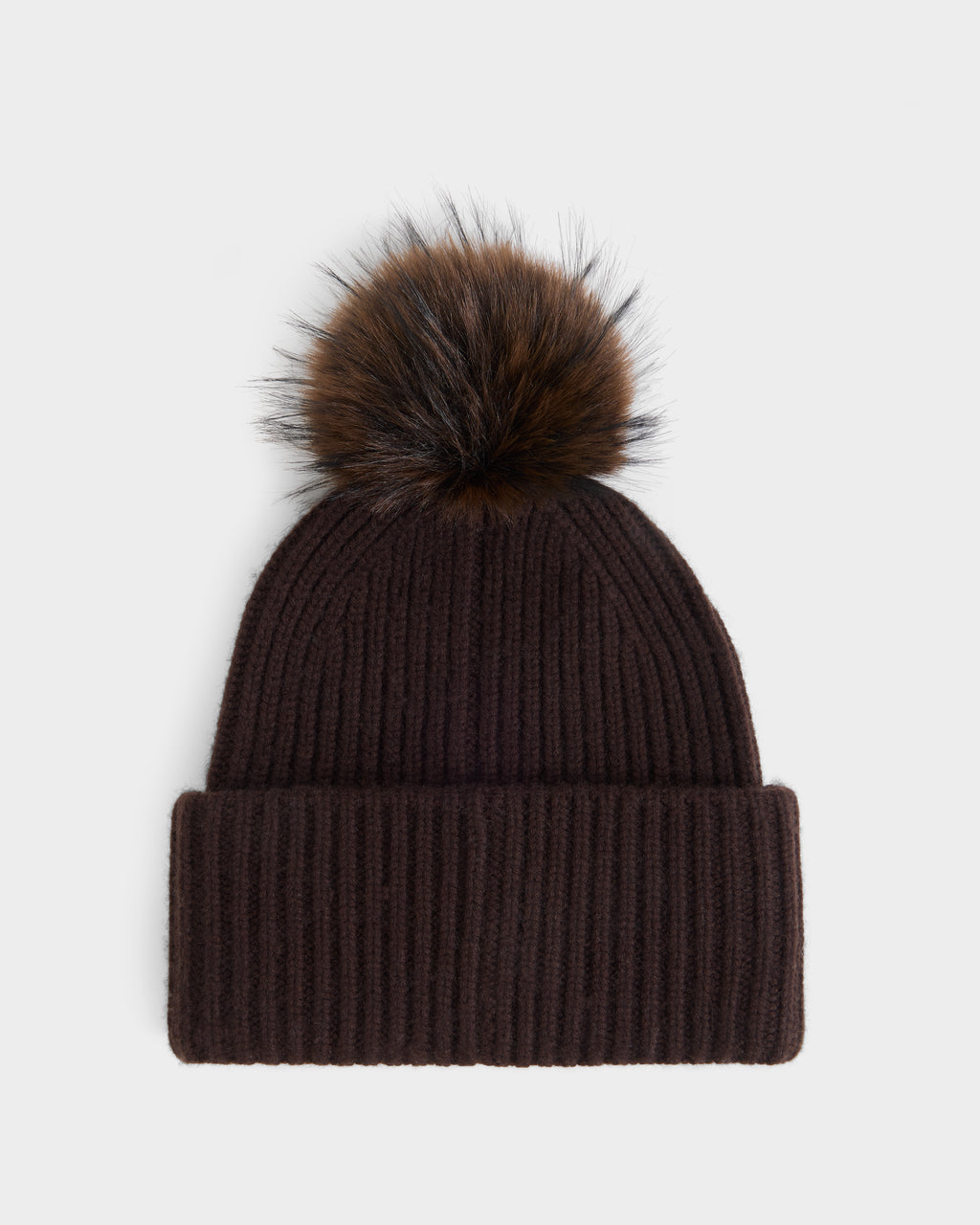 The Rudsak DARA - 8425019 Espresso is a dark brown ribbed knit women’s winter hat, featuring a folded brim and topped with a large faux fur pom pom, shown against a plain white background.