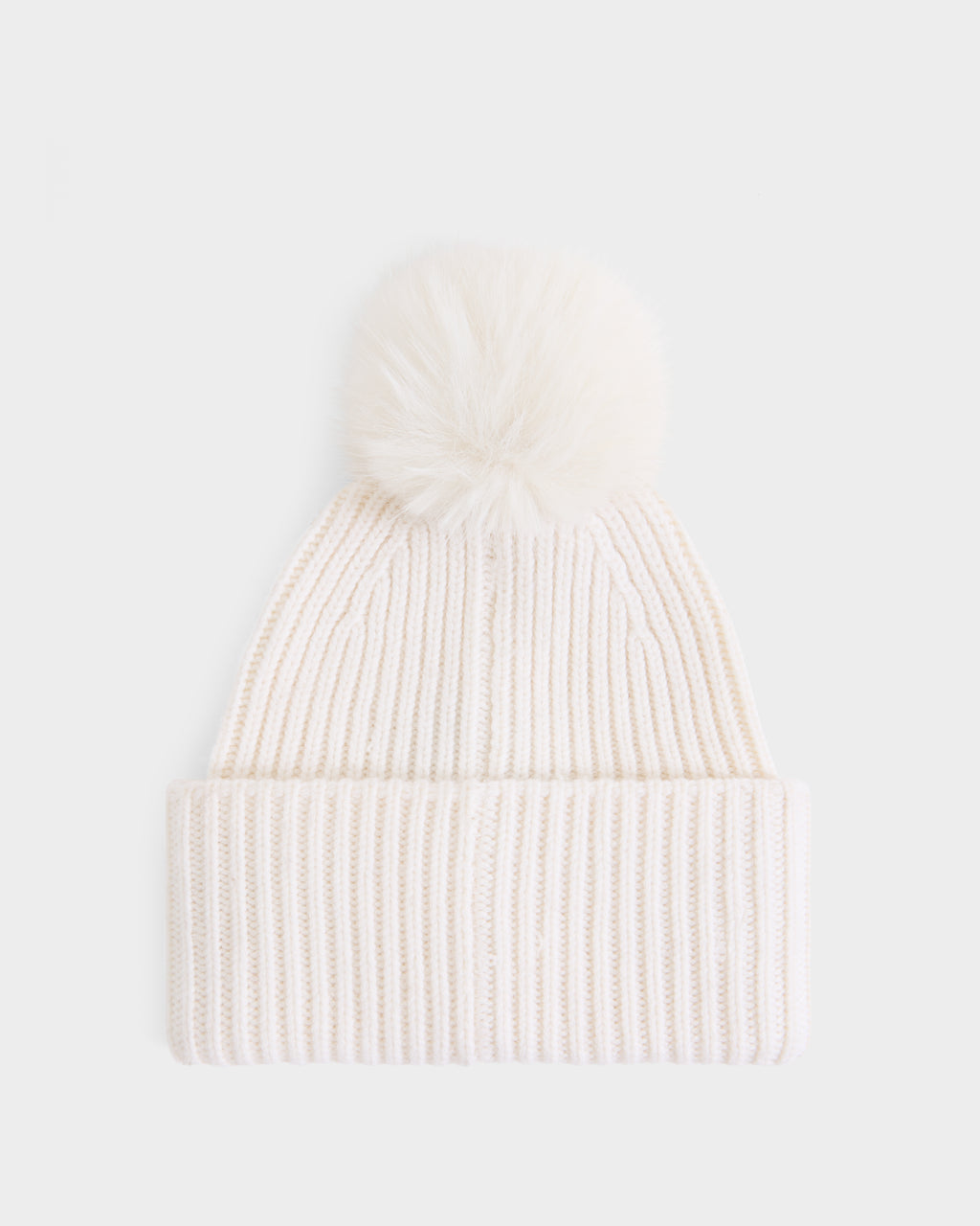 The DARA - 8425019 Vanilla by Rudsak is a women’s white ribbed knit tuque featuring a folded brim and a large, fluffy faux fur pom pom on top. Crafted from a soft cashmere wool blend, it is shown against a plain white background.