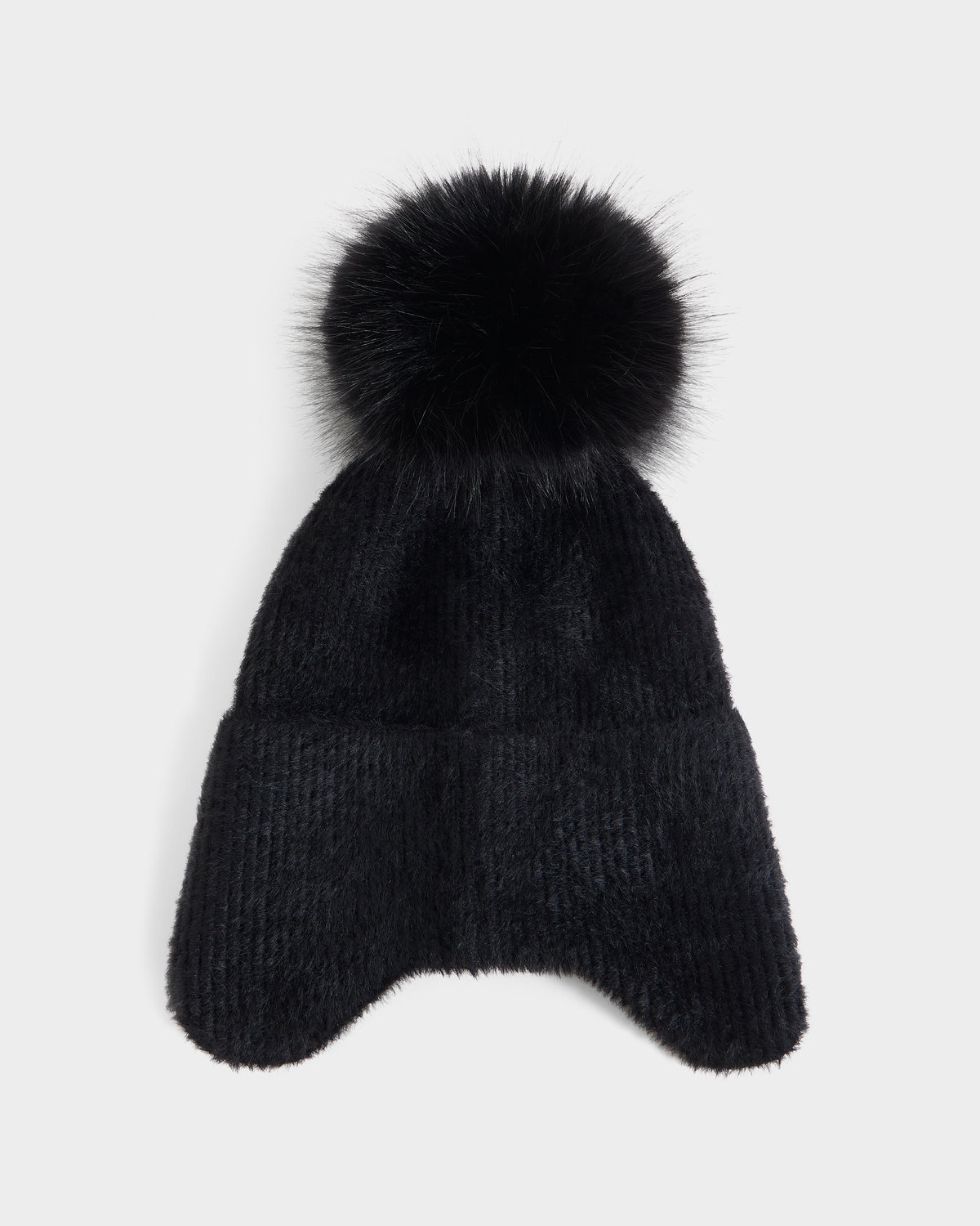 The Rudsak ICE - 8426519 Black is a black knit winter hat featuring ear flaps and a large faux fur pom-pom on top, displayed on a plain white background.