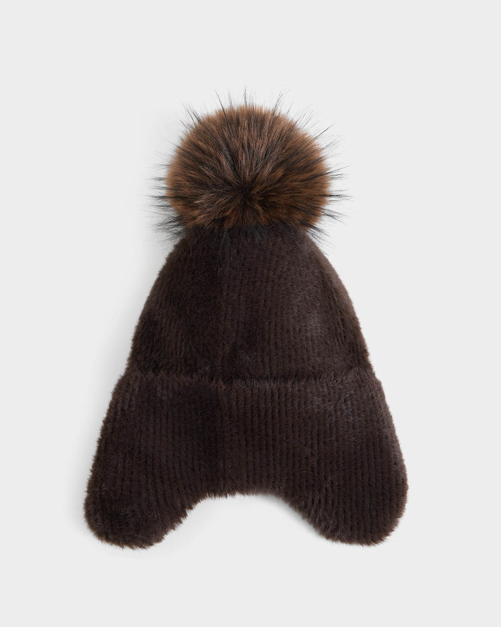 The Rudsak ICE - 8426519 Espresso is a dark brown, furry winter hat featuring two ear flaps and a large, fluffy pom-pom on top, displayed on a white background.