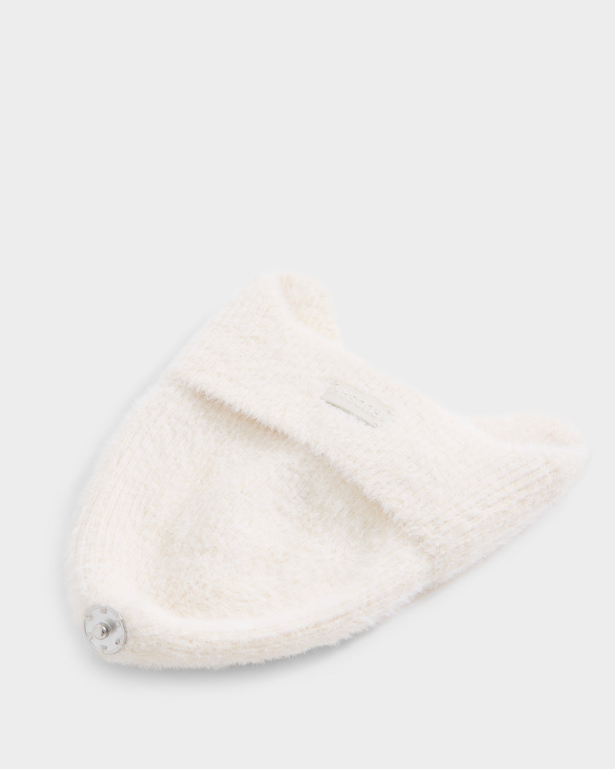 A soft, white knit headband from Rudsak, called ICE - 8426519 Vanilla, featuring two small pointed ear shapes and a round silver button on one end, is displayed on a plain light background.