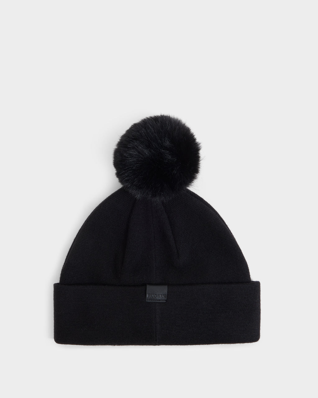 The Rudsak ESTELLA - 8426521 Black beanie features a large faux fur pom-pom on top and a folded cuff, shown against a plain white background.