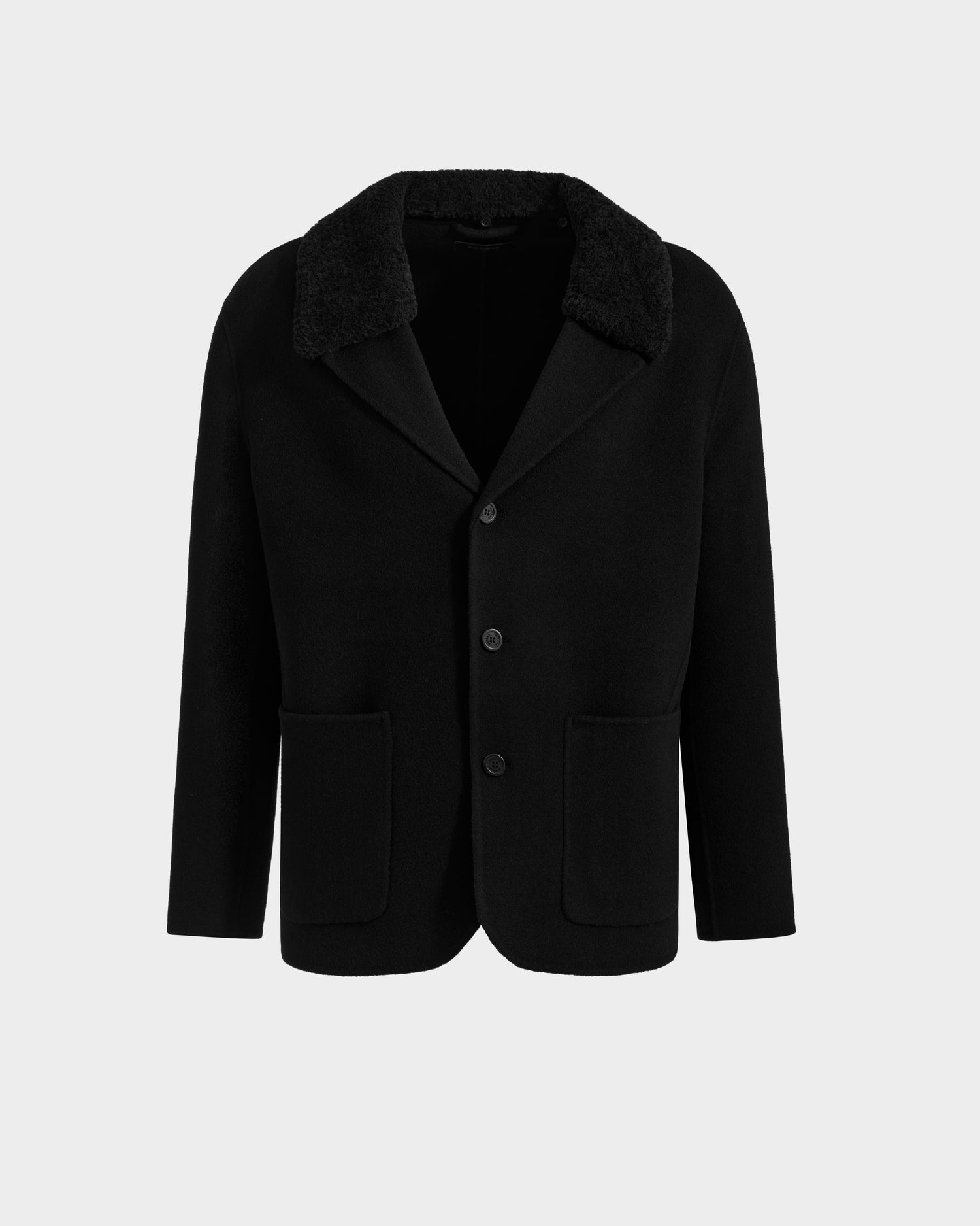 The Rudsak AIDEN - 6125558 Black blazer features black wool, three buttons, a large notched collar with removable faux shearling, and two front patch pockets. Shown on a plain light gray background.