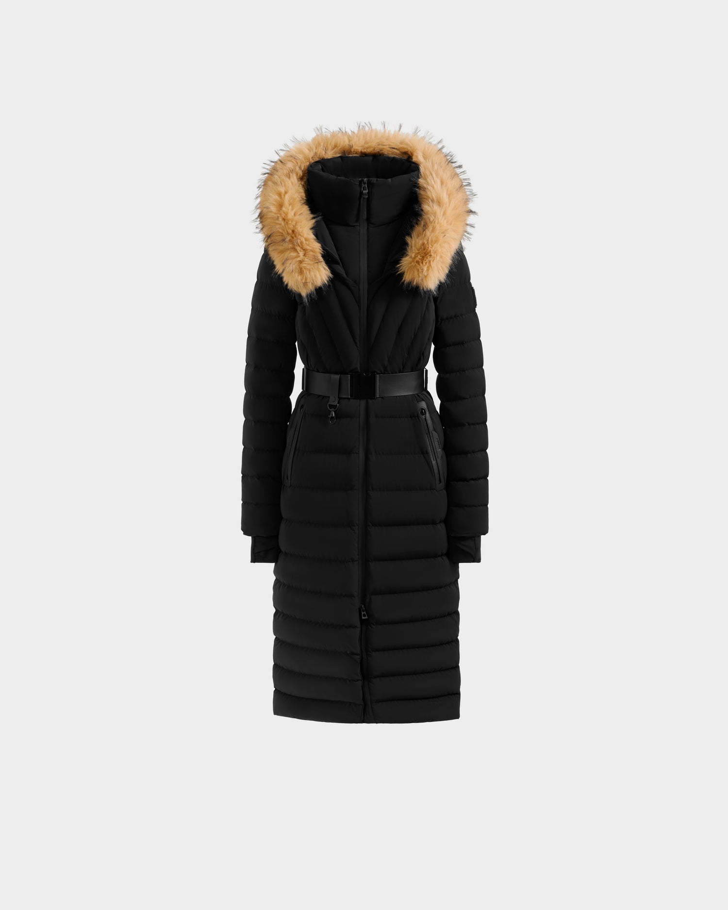 The Rudsak ALISA L - L125574 Black is a long black quilted puffer coat with a belted waist, front zipper, and hood with tan faux-fur trim, shown on a plain light gray background.