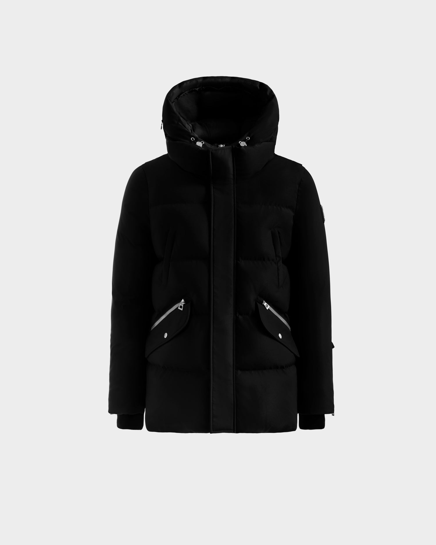 The Rudsak APOLLO H - 6125690 Black is a black winter parka with a hood, front zipper closure, and two angled front pockets with silver zippers, shown on a plain white background.