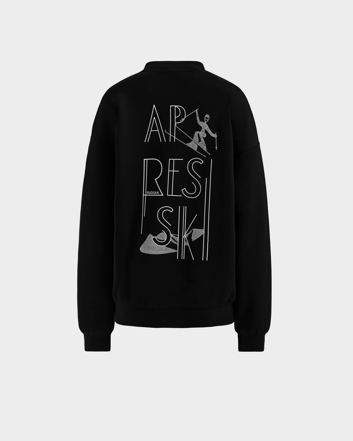 The Rudsak ARIA - 8525661 Black women's crewneck sweatshirt features a back graphic with tall APRES SKI letters, a skier, two skis, and a sparkling rhinestone ski design for standout après-ski style.