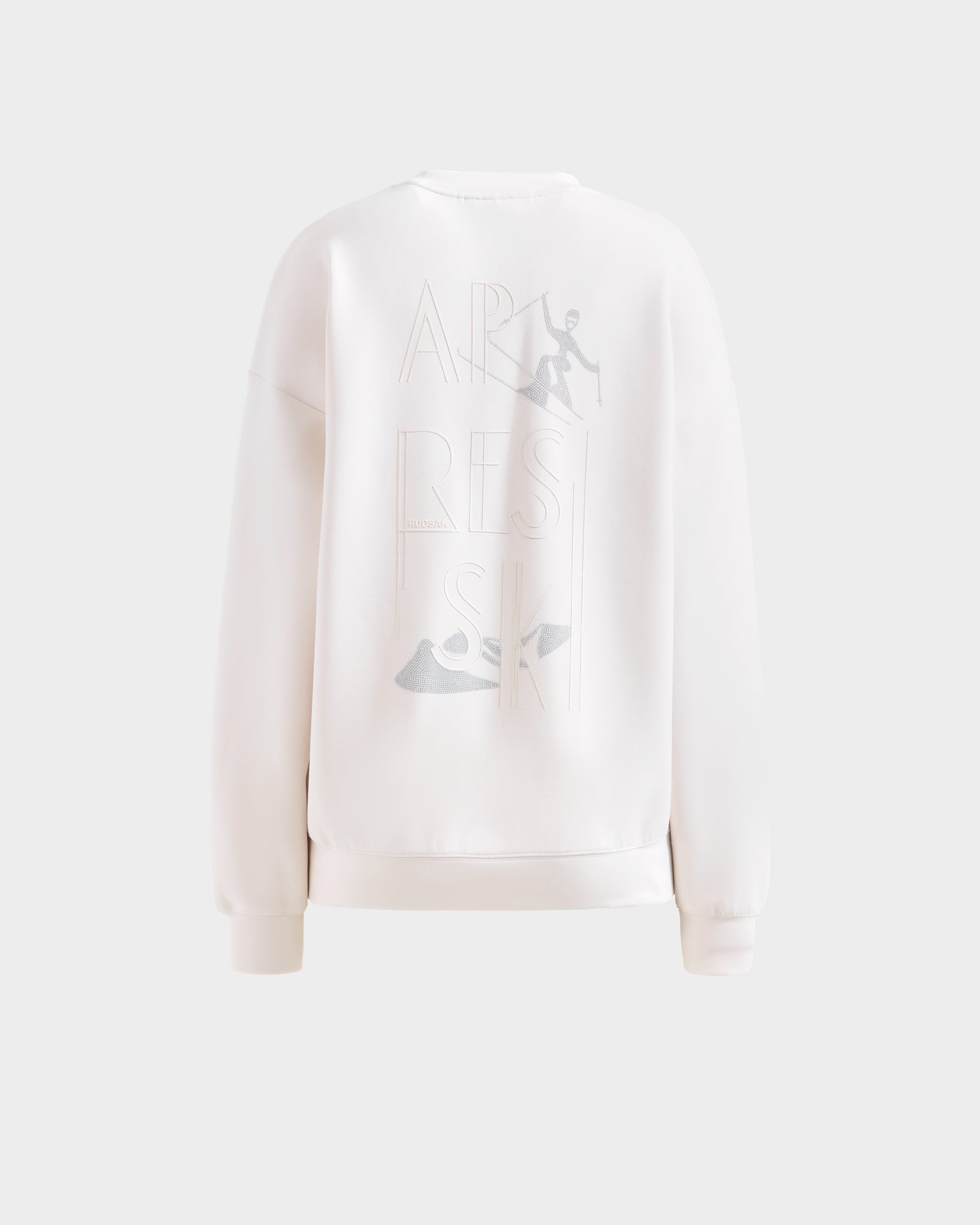 The Rudsak ARIA - 8525661 Vanilla is a white women’s crewneck sweatshirt with an embossed APRES SKI design, skier and ski boot graphics—an ideal après-ski pullover for fans of subtle ski-themed sweatshirts.