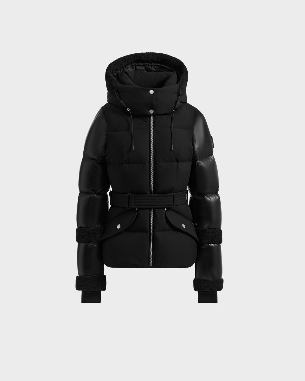 The Rudsak AUDREY - 8124582 Black/Black is a black down puffer jacket with hood, snap buttons, belted waist, and cuffed sleeves, made from recycled Stormshell fabric and shown on a plain light gray background.