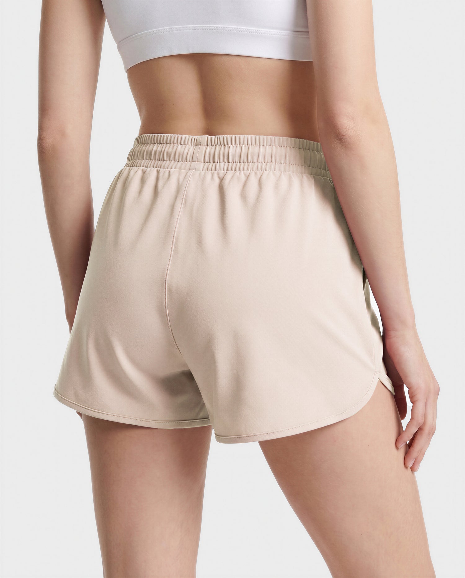 A person stands with their back to the camera, wearing the Rudsak SAMMY - L523014B Bottom in Cream against a plain background.