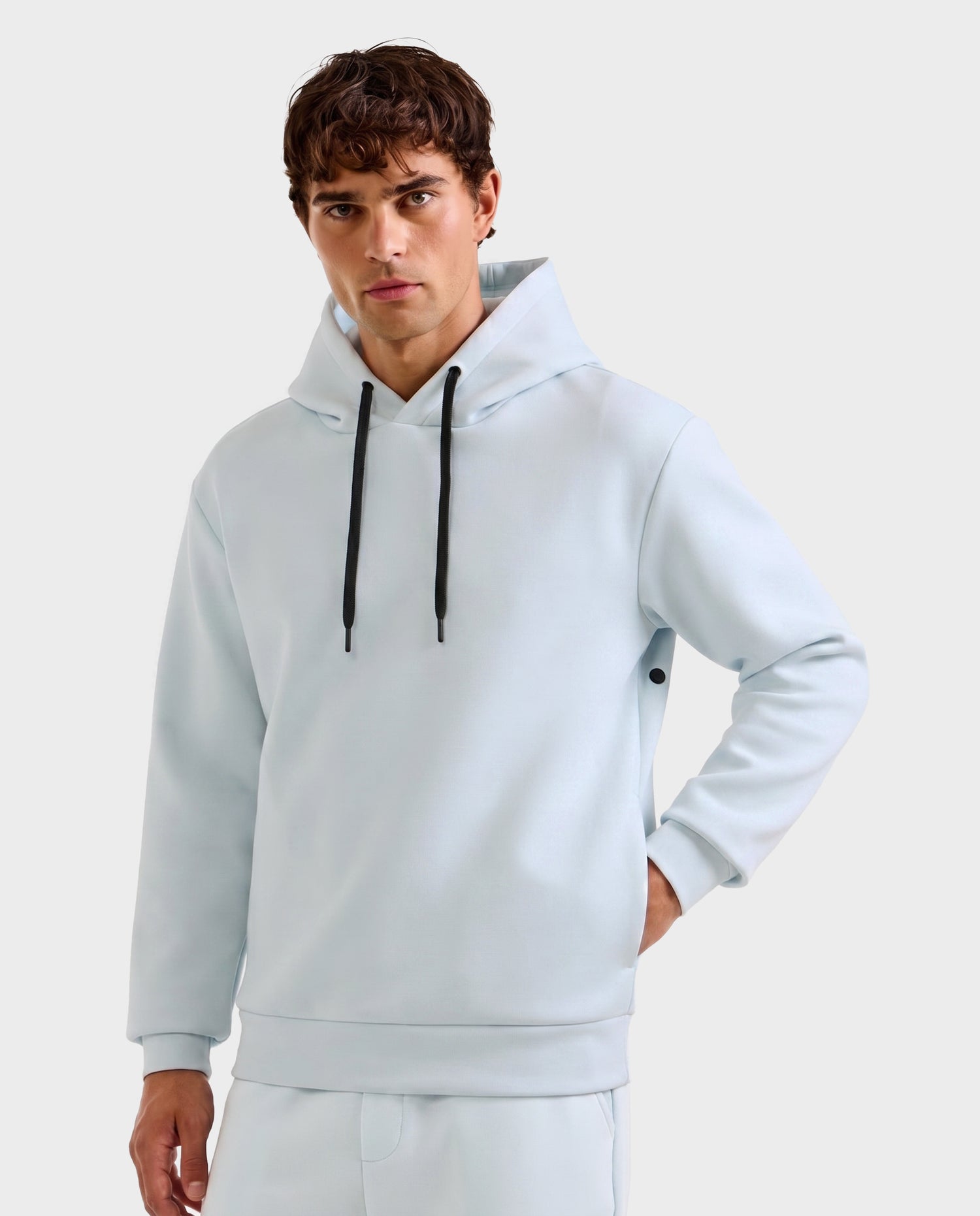 A young man with short brown hair wears the Rudsak LEROY - U525509 Sky Blue M hoodie with black drawstrings and matching pants, standing against a plain light gray background.