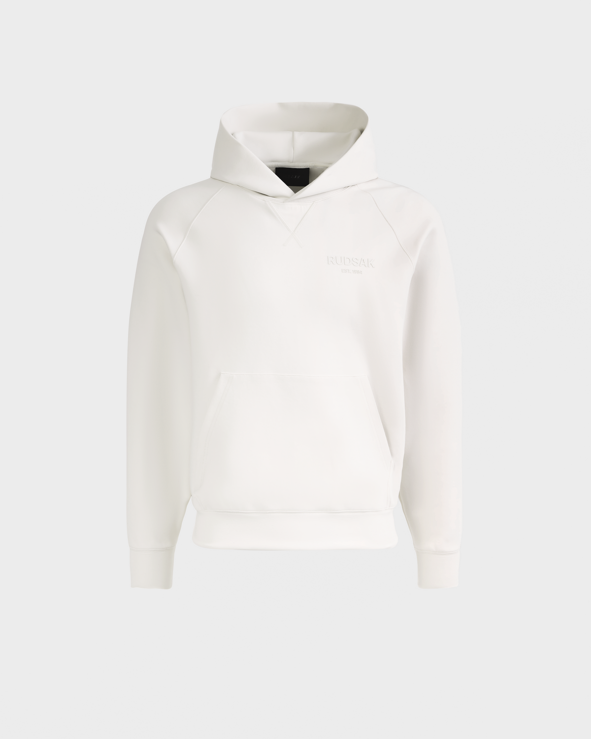 The Rudsak BARRY - 9524011 Vanilla W is a plain white unisex hoodie featuring long sleeves, a front kangaroo pocket, ribbed cuffs and hem, and subtle embossed chest text, shown on a light grey background.