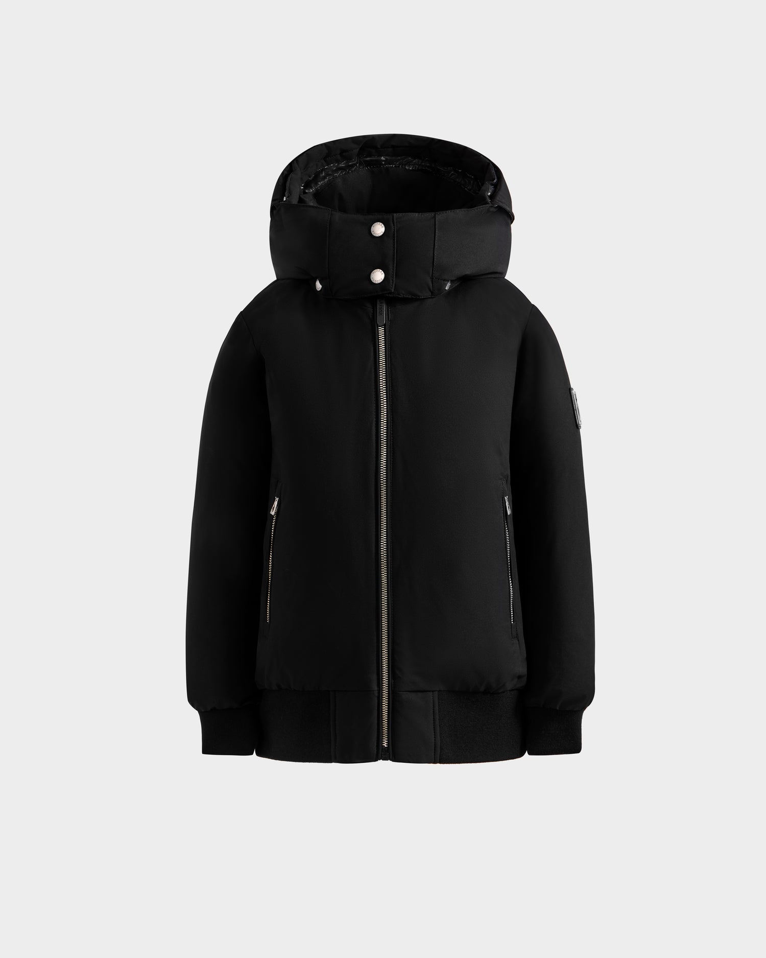 The Rudsak BOOKER K - 0124500 Black is a kids’ black weather-resistant quilted puffer jacket with a front zipper, two side zippered pockets, and snap buttons on the collar, shown on a plain light gray background.