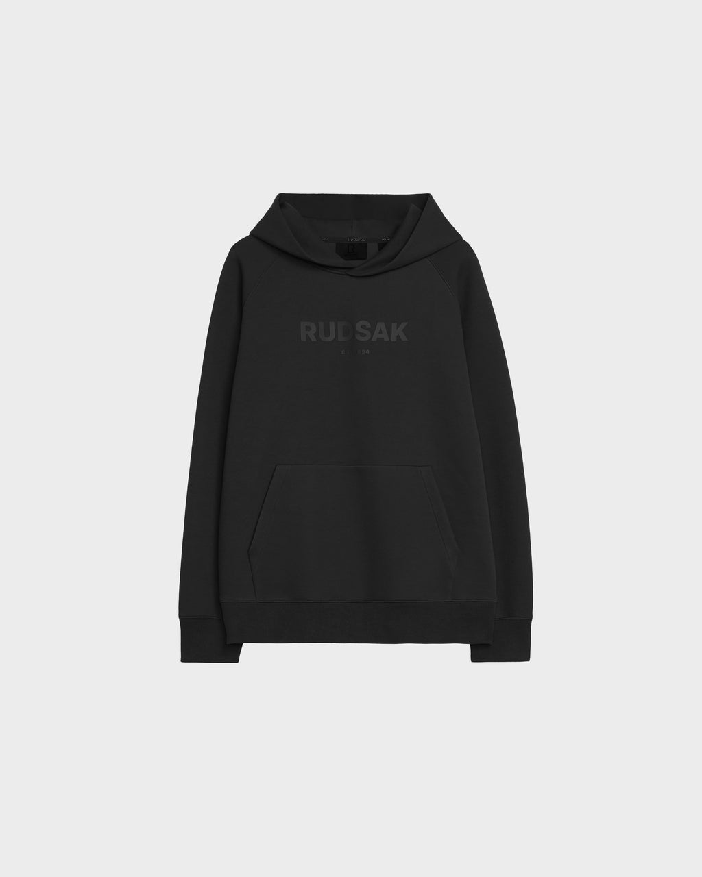 The Rudsak BRIAR - 9525001 Black M is a unisex premium cotton hoodie with a front pouch pocket and subtle "RUDSAK" branding across the chest, displayed on a plain light gray background for casual comfort and style.