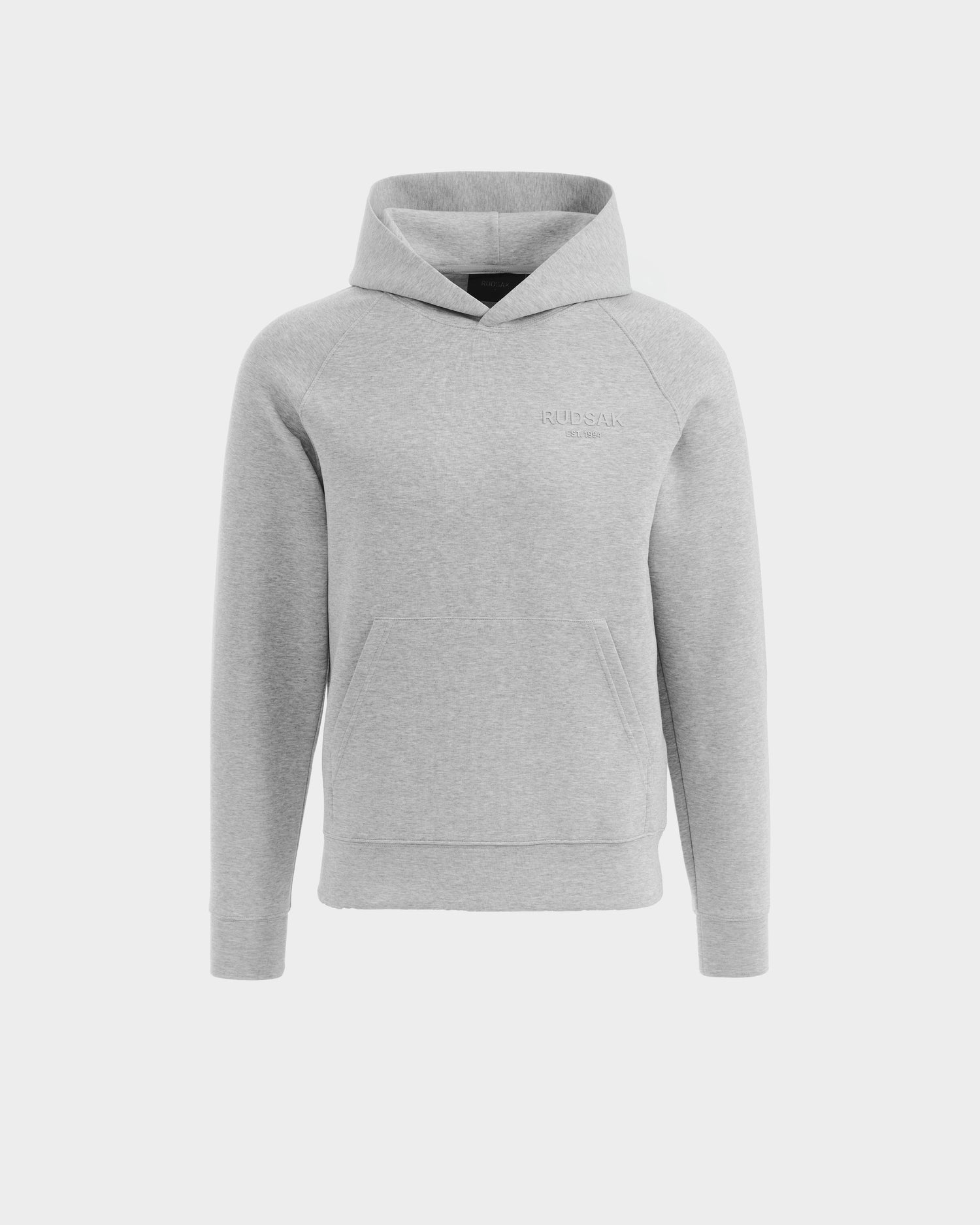 The Rudsak BRIAR - 9525001 Heather Grey M is a unisex hoodie in light gray, made from a premium cotton blend with long sleeves and a front pocket. Its simple, casual design is shown on a plain white background with minimal visible branding.