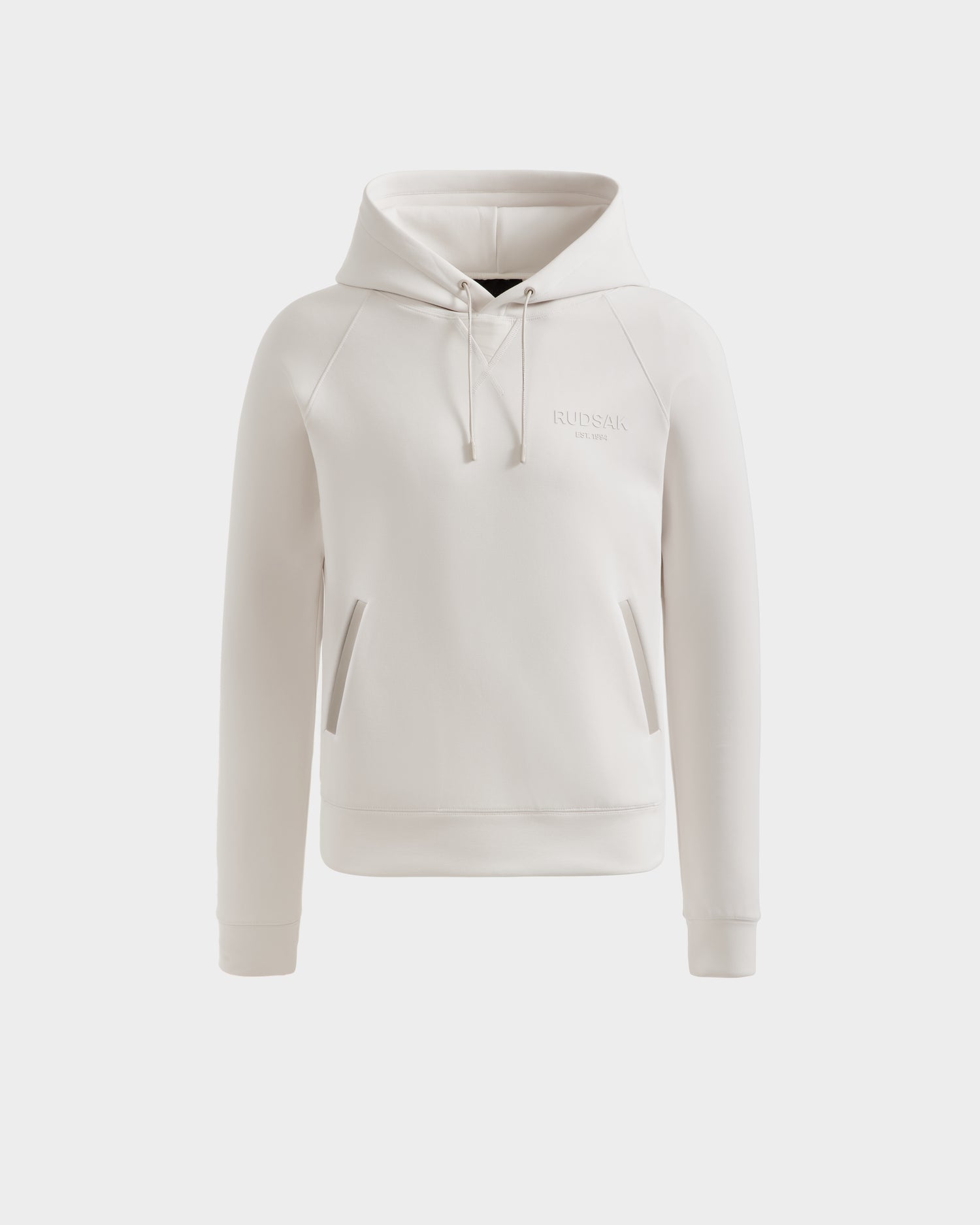The Rudsak BROOKLYN - 6525593 Vanilla men's hoodie features a front pocket, drawstrings, and subtle chest embroidery for urban style, shown in off-white against a white background.