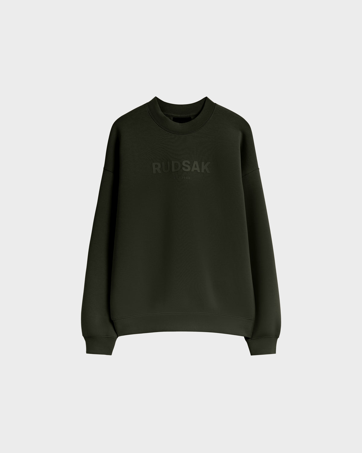 The BRYN - 9524007 Dark Olive W by Rudsak is a dark green cotton crewneck sweatshirt with long sleeves, featuring a subtle Rudsak chest print and genderless sizing. Shown on a plain light grey background.