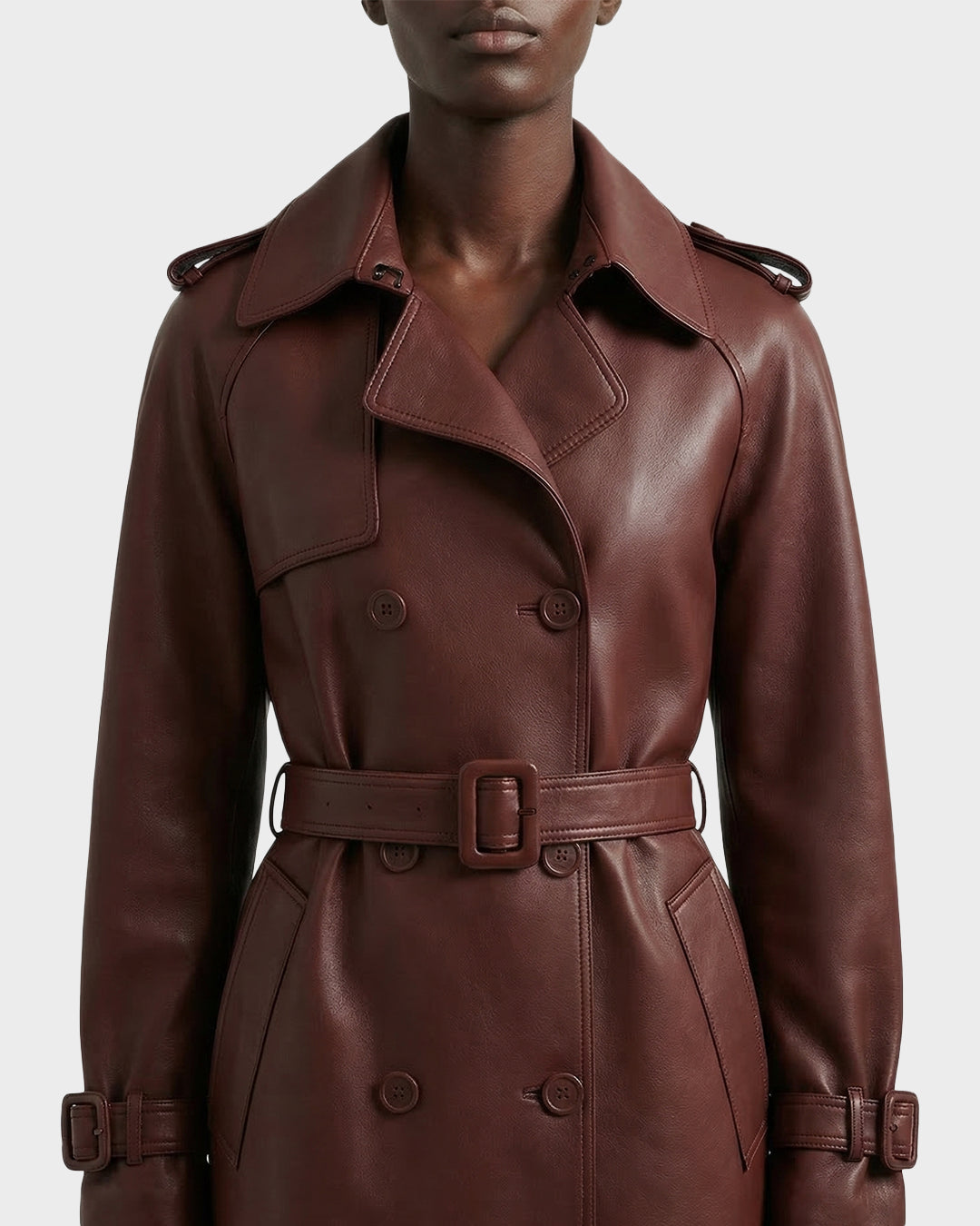 A person wearing the Rudsak CASSIE L-B - 8125553 Rust double-breasted trench coat with a belted waist and wide lapels, shown from shoulders to mid-thigh against a plain background.