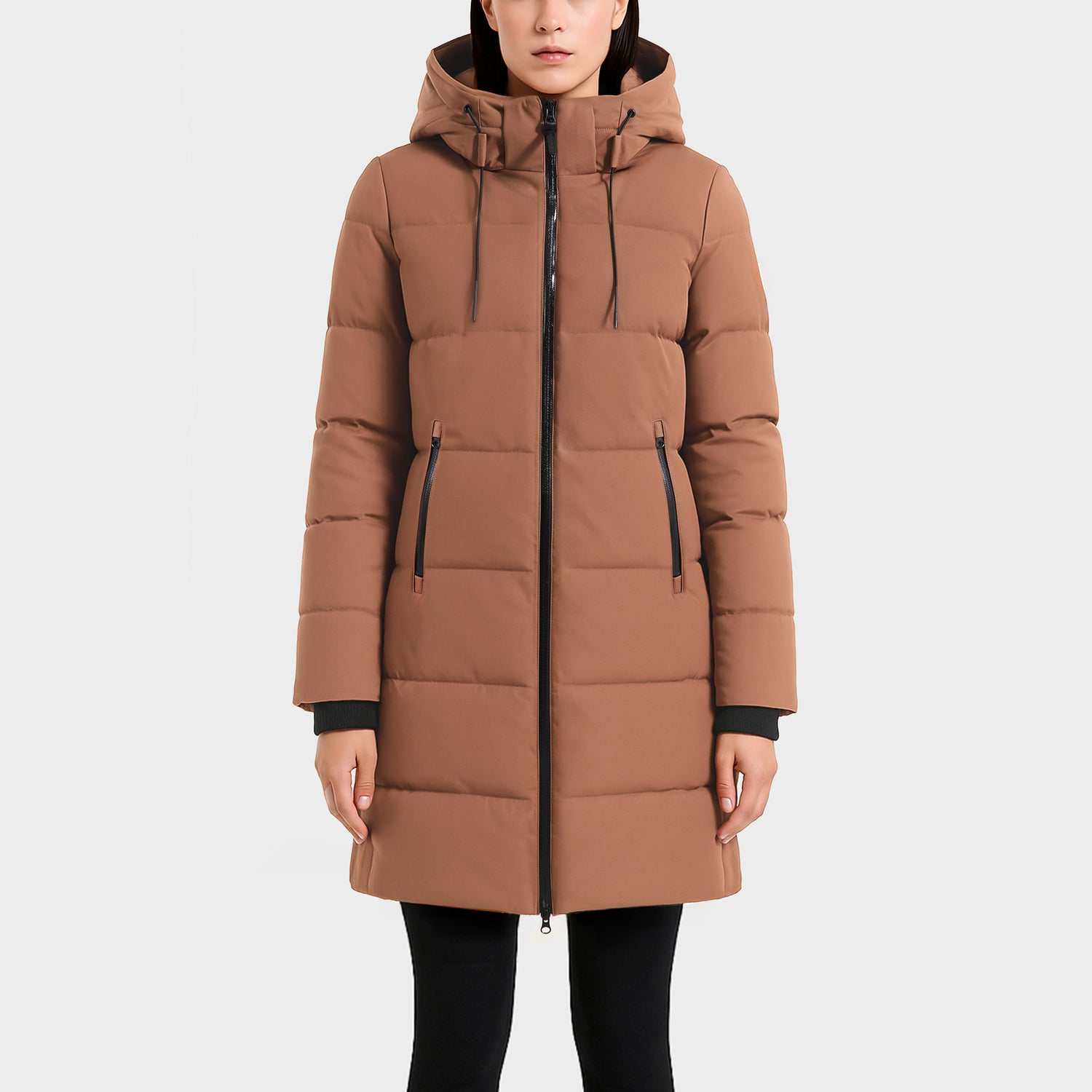Someone wearing the Rudsak SYDNEY COM - 4123511 Taupe, a long taupe hooded duck-down parka with front zipper and zippered pockets, stands against a plain light background.