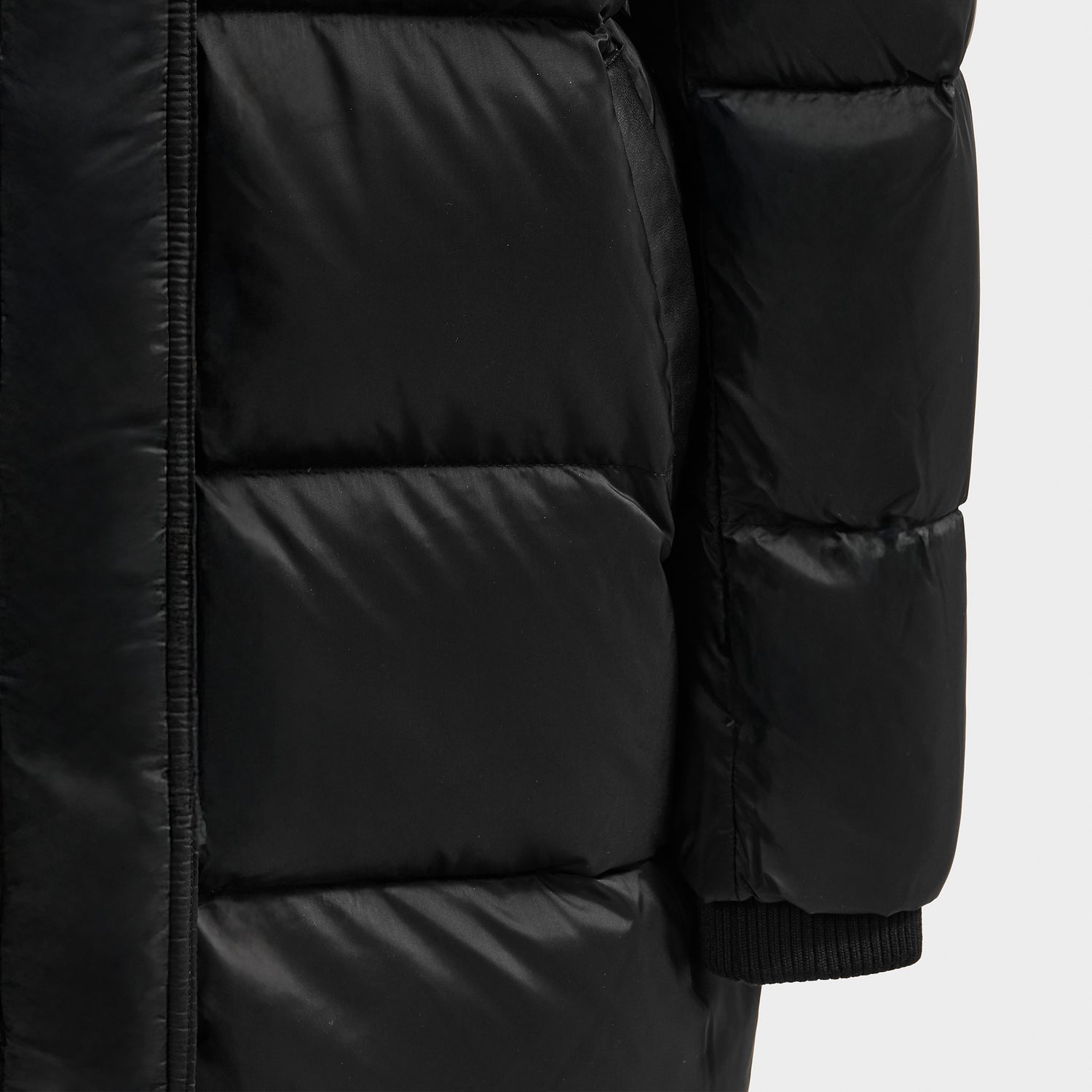 Close-up of the Rudsak OLIVIA - 4123509 Black puffer jacket, highlighting the quilted, padded sections and a sleeve with a ribbed cuff. The fabric is smooth and slightly shiny.