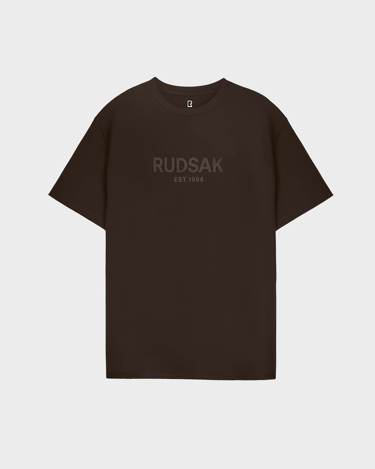 A comfortable must-have, the mens CASEY - 6525037 Espresso T-shirt by Rudsak features RUDSAK EST. 1994 in dark lettering on the chest against a plain black background.