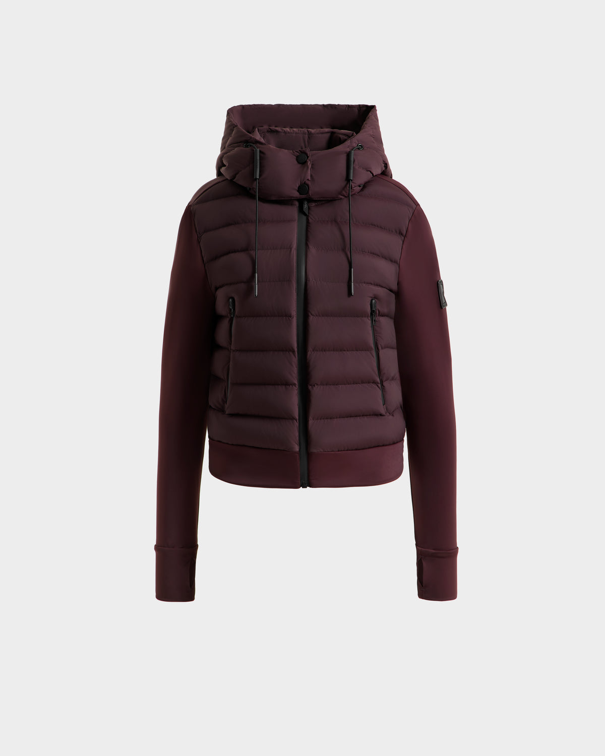 The Rudsak CASSA - 8125057 Bordeaux is a maroon women's transitional jacket with a hood, front zipper, and black drawstrings. Featuring horizontal quilting and ribbed cuffs, this lightweight cropped jacket is shown against a white background.