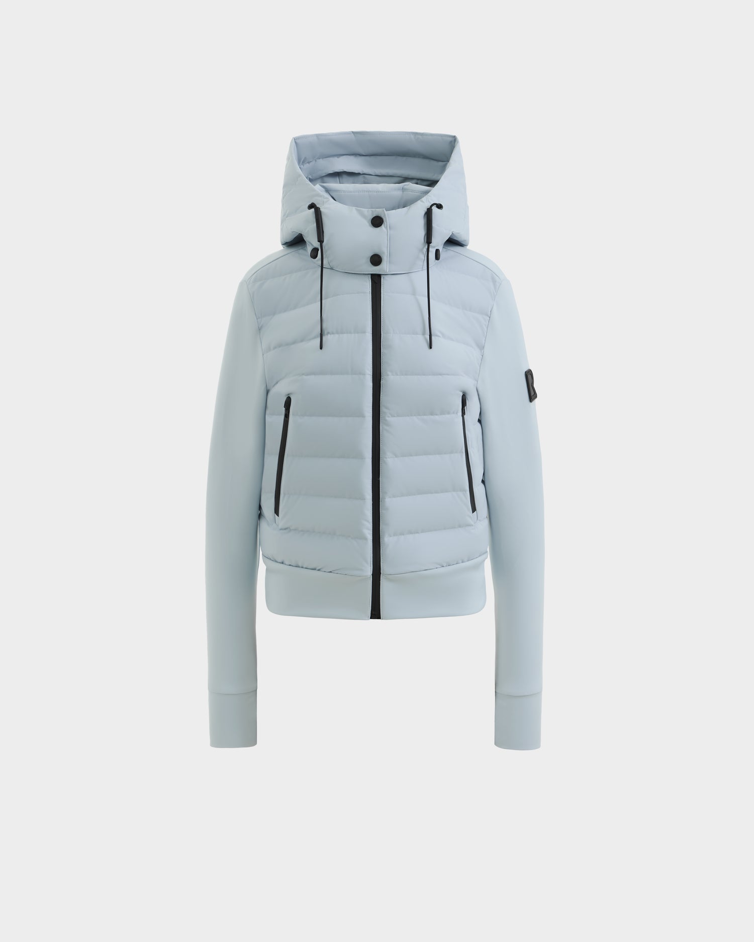 The CASSA - 8125057 Powder Blue by Rudsak is a light blue, quilted, cropped women’s jacket with a hood, front zipper, two zippered side pockets, and black accents, shown on a white background.