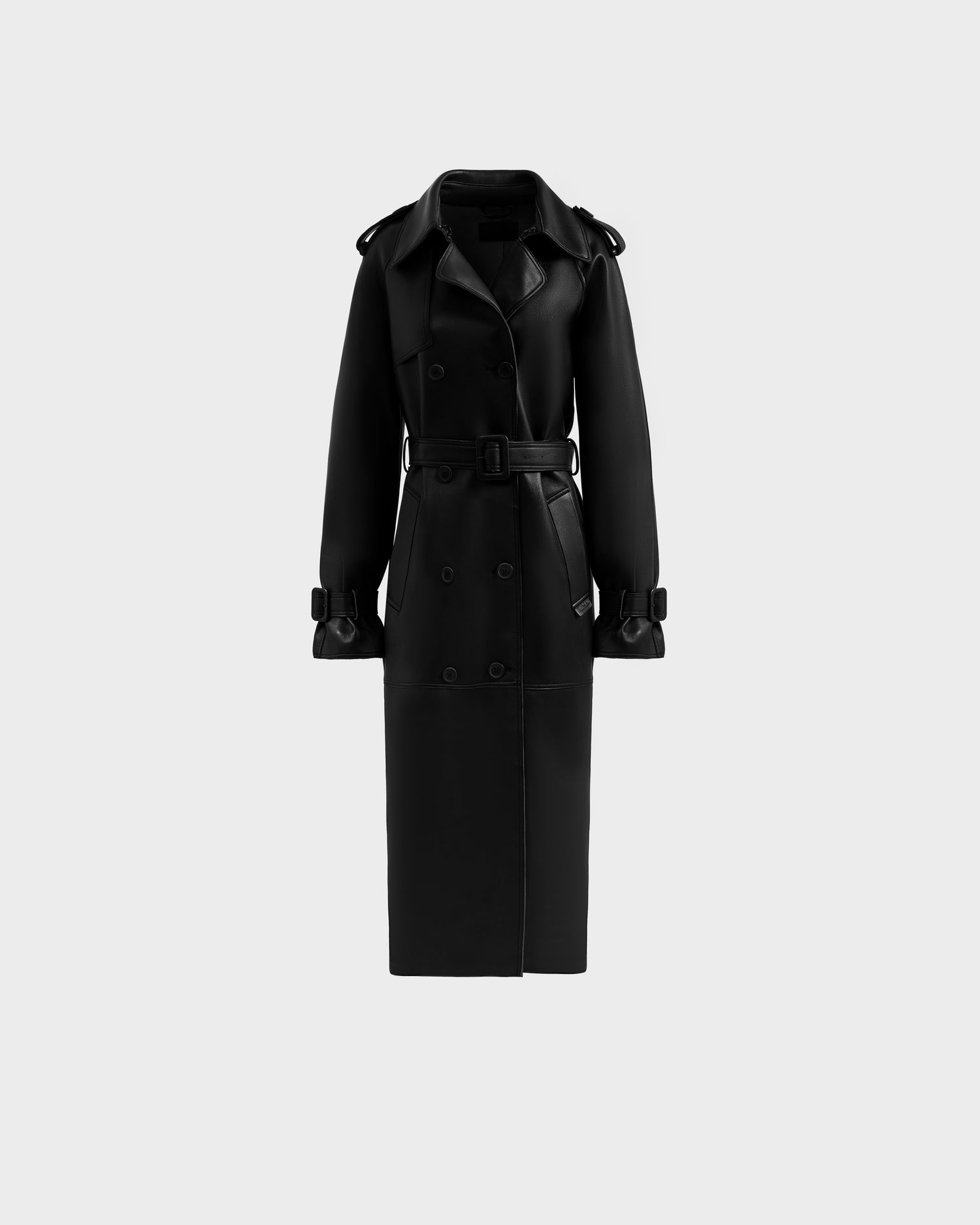 The Rudsak CASSIE L-B - 8125553 Black is a women’s long double-breasted trench coat in bonded leather, with a belted waist, wide lapels, and buttoned sleeve straps, shown on a plain light gray background.