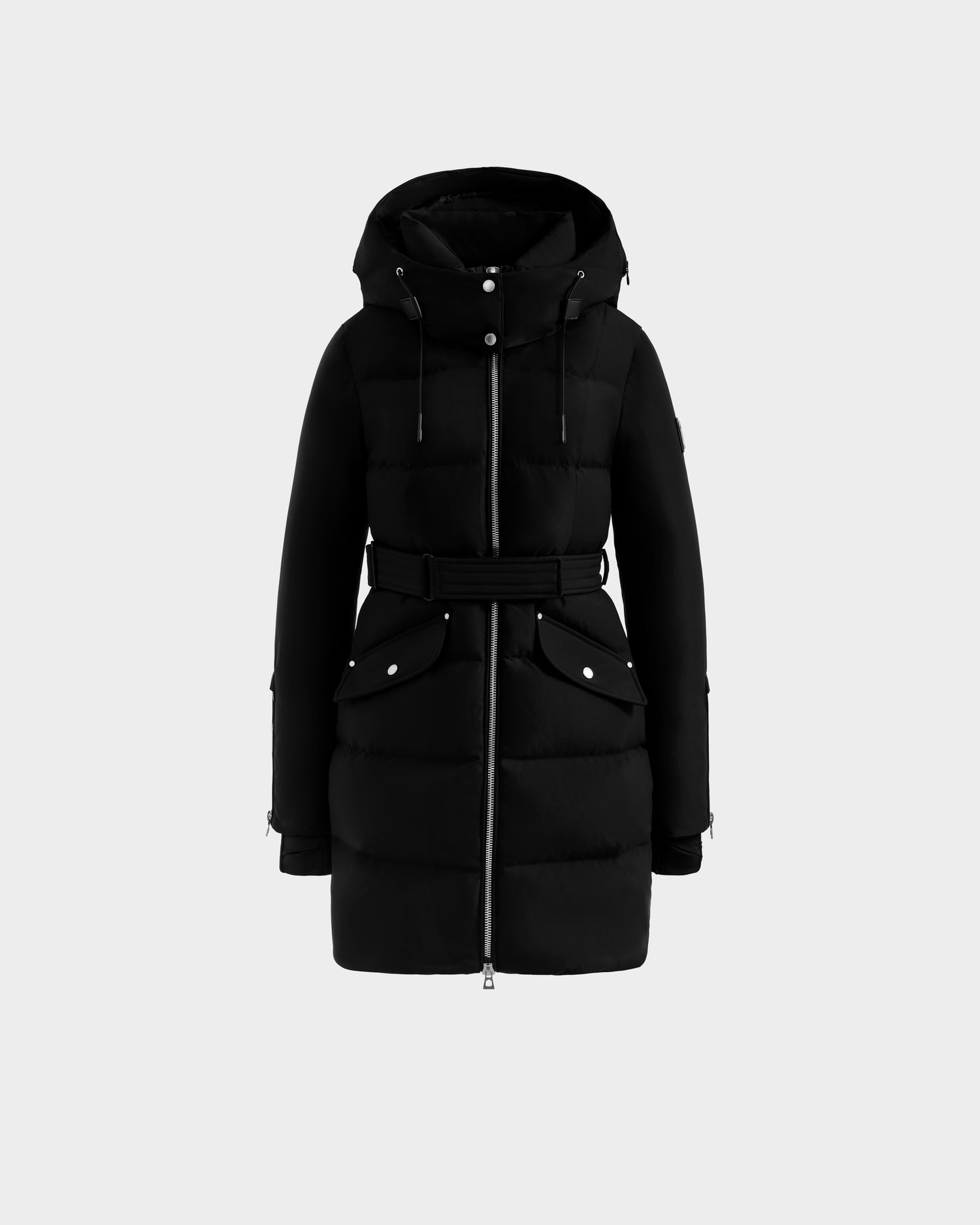 The Rudsak CAT H - 8125588 Black is a women’s knee-length down puffer coat with a hood, front zipper, belted waist, and large flap pockets, shown against a plain light gray background.
