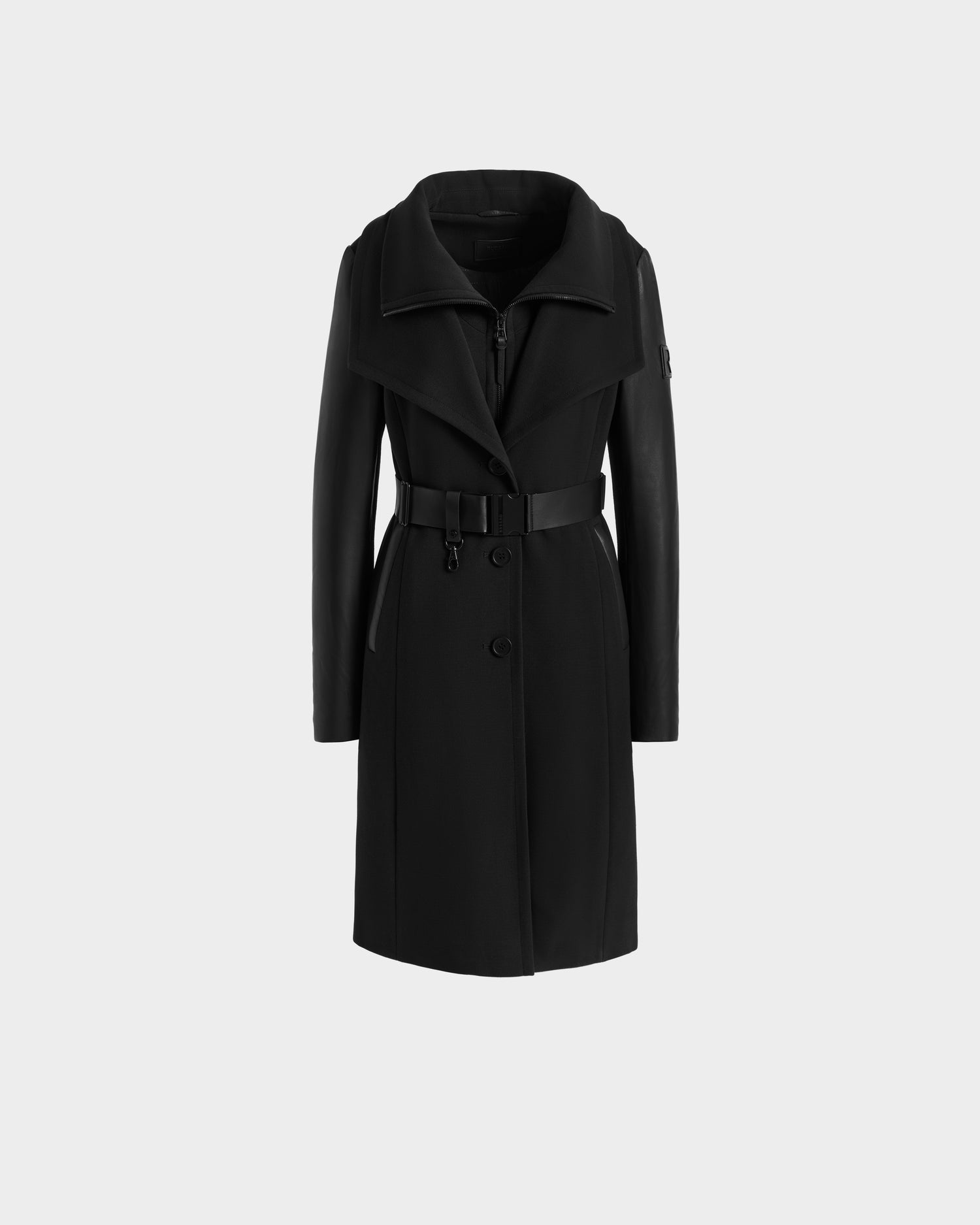 The CELESTE - L124542 Black by Rudsak is a modern black trench coat featuring a wide collar, belted waist, front buttons, and sleek leather sleeves, shown against a plain light gray background.