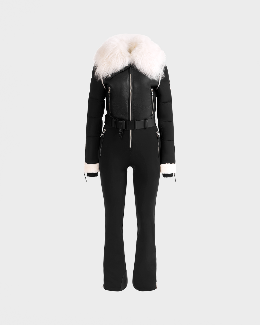 The Rudsak CHYNTIA - 8125611 Black: a black fitted jumpsuit with zip front, belted waist, white faux fur collar and cuffs, shown on a light gray background. Available for pre-order; ships by November 30th.