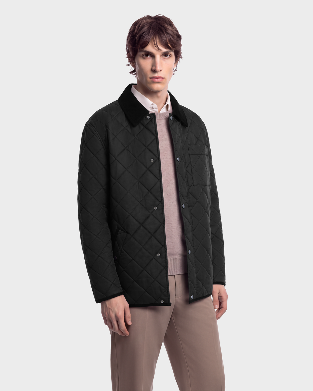 A man wears a black Rudsak MONTY - 6126722 Black quilted jacket with a corduroy-textured collar over a light-colored sweater and tan trousers.