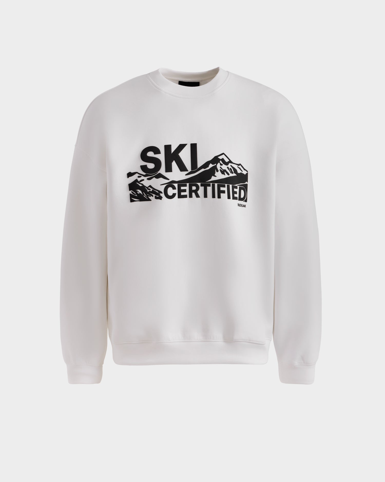 The DECLAN - 6525648 Iceland men’s crewneck sweatshirt by Rudsak features “SKI CERTIFIED” in bold black letters with a mountain graphic—a stylish white sweater for fans of clean, graphic designs.