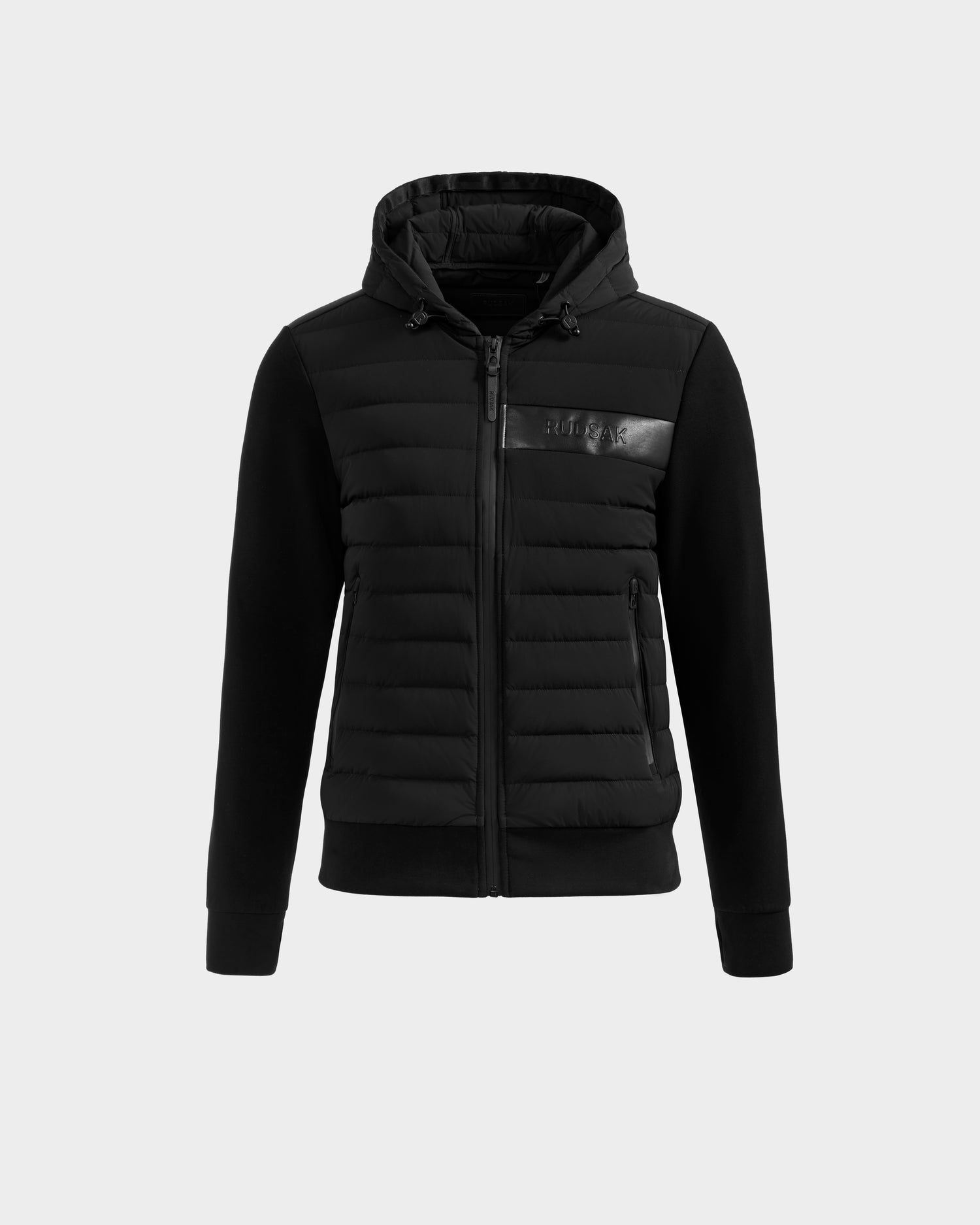 The Rudsak DEE MP - 6125673 Black is a men’s lightweight down jacket with quilted front, smooth sleeves and hood, waterproof zipper, zippered side pockets, and an embossed logo on a glossy strip. RDS-certified duck down fill.