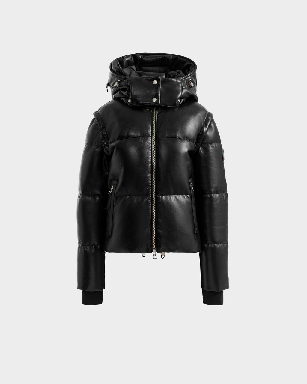 The DELILAH PX - L125537 Black by Rudsak, a women’s vegan-leather puffer jacket with a shiny finish, front zipper, high collar, attached hood, and ribbed-cuff long sleeves is shown on a plain light grey background.