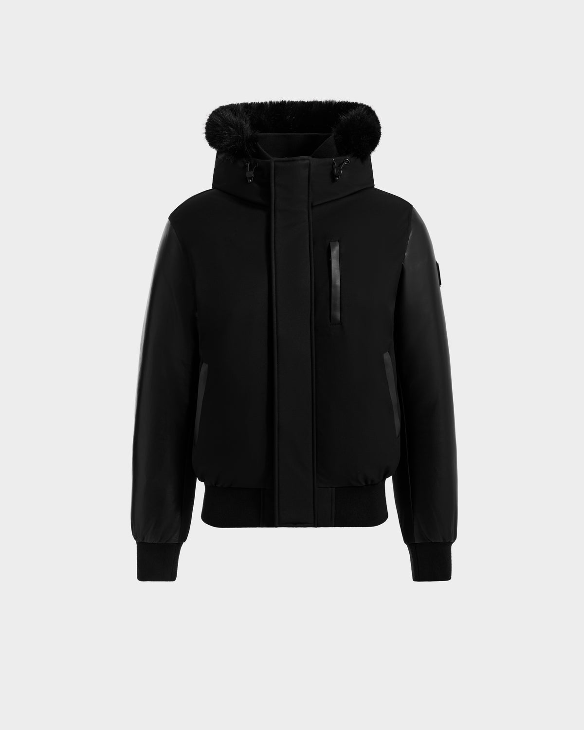 The Rudsak DERON - M125539 Black men’s down bomber jacket features a front zipper, ribbed cuffs and hem, vegan-leather sleeves, two side pockets, one chest pocket, and a fur-trimmed hood, shown on a plain light gray background.