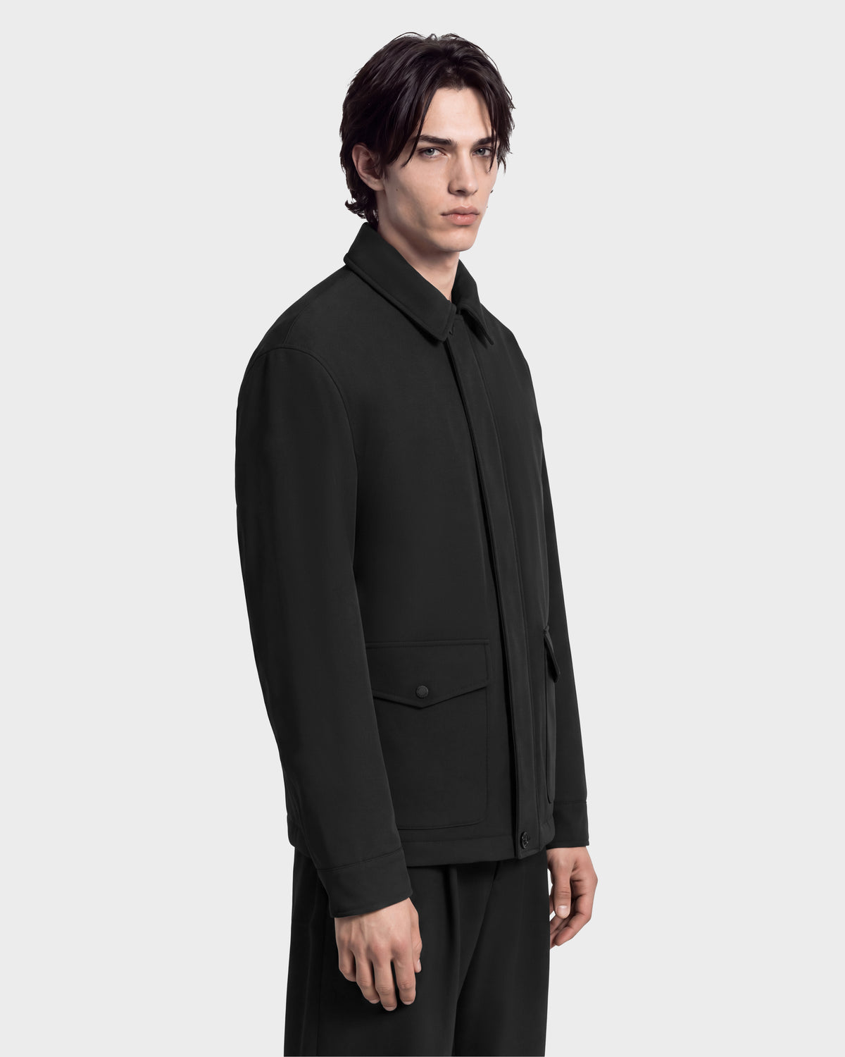 A person wearing the Rudsak ANTOINE - 6126506 Black utility jacket, featuring a refined design with a black collar and two front flap pockets.