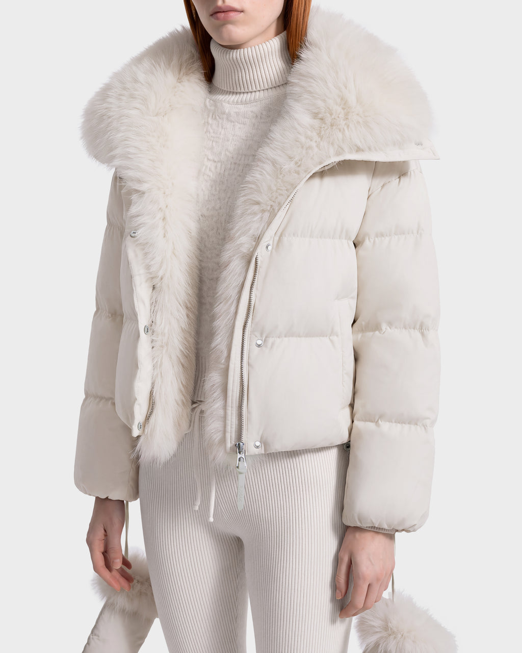Rudsak ALONDRA - 8126992 Vanilla cream-colored cropped puffer jacket with a wide faux fur collar and trim, worn over a matching ribbed turtleneck sweater and knit pants.