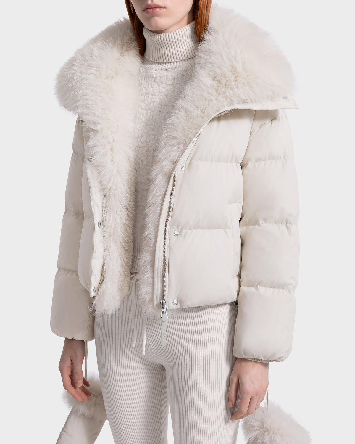 Rudsak ALONDRA - 8126992 Vanilla cream-colored cropped puffer jacket with a wide faux fur collar and trim, worn over a matching ribbed turtleneck sweater and knit pants.