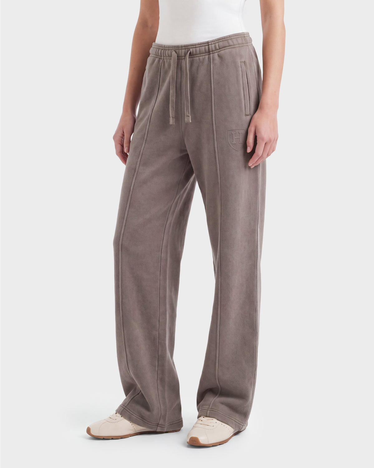 A person wearing the Rudsak GAELLE HV - H526902 Taupe heavyweight jersey jogger sweatpants with side pockets and a white tank top, standing against a plain white background.