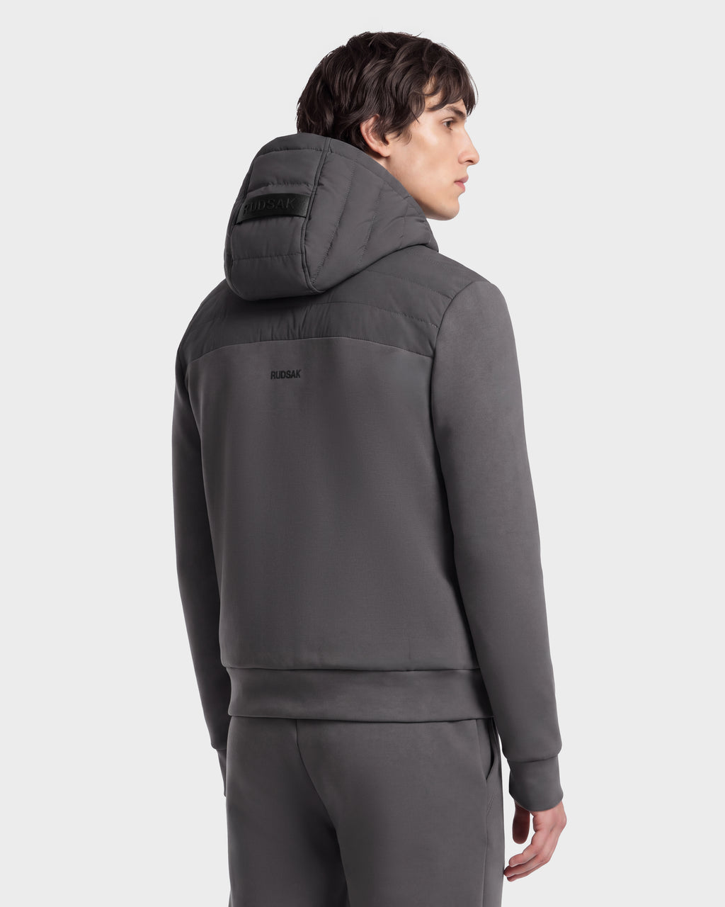 A person seen from the back wearing a grey DEE MAT - 6124028 Grey lightweight hybrid down jacket with a quilted upper back panel and matching pants.