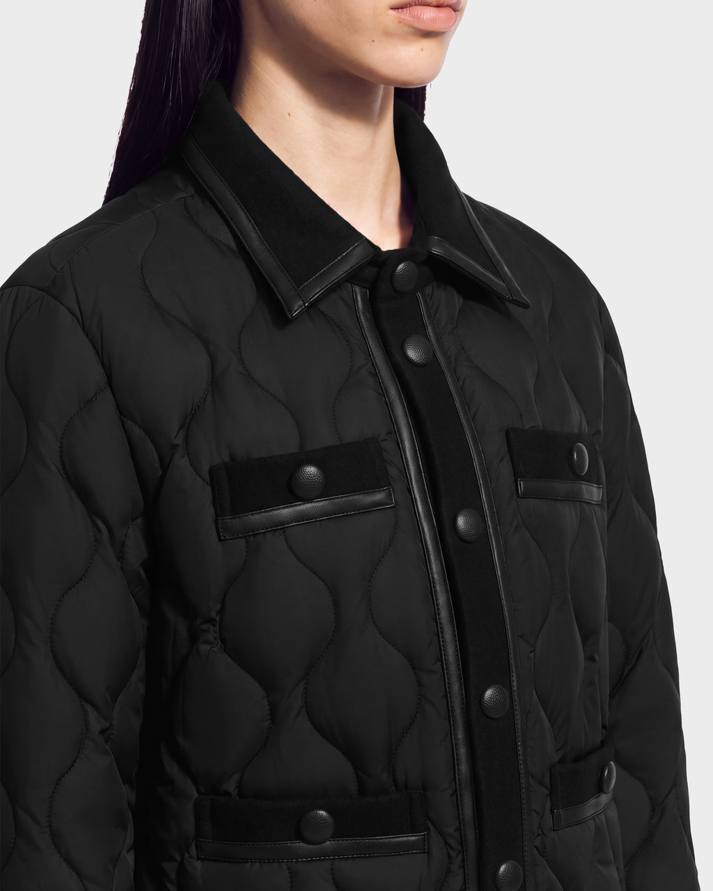 Close-up of a black JOLIE - 8125036 RUDSAK women’s quilted down jacket with a button-up front and two chest pockets featuring buttoned flaps and trim.