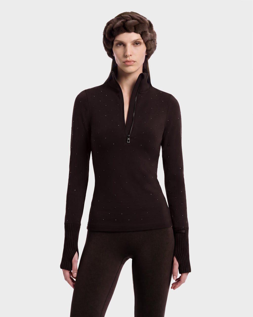 A person wearing a dark brown NEVA - 8526524 Espresso après-ski top with subtle stud detailing and matching stretch nylon leggings, accessorized with a brown fur headband.