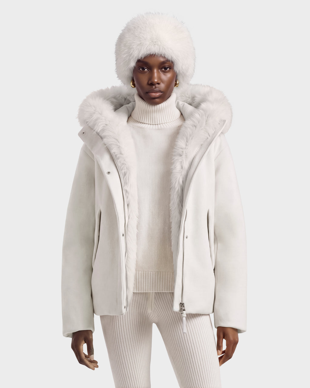 A person wearing a HAZEL - 8126981 Vanilla white wool-blend winter coat with a detachable faux-fur hood, a matching fur hat, and a ribbed turtleneck sweater.