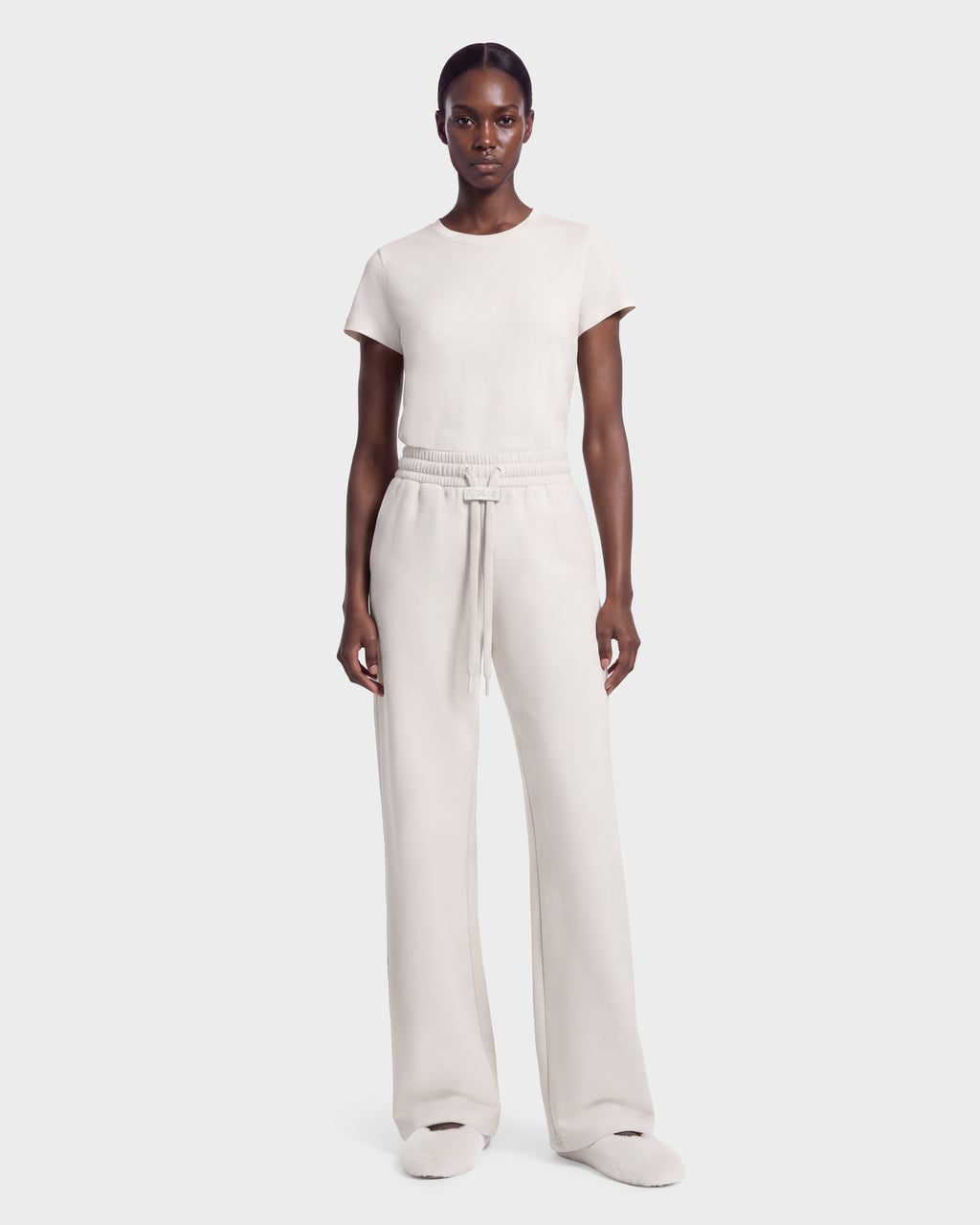 A model wearing a vanilla-colored ANGEL - 8526725 short-sleeved t-shirt and matching wide-leg drawstring sweatpants for a refined off-duty look.