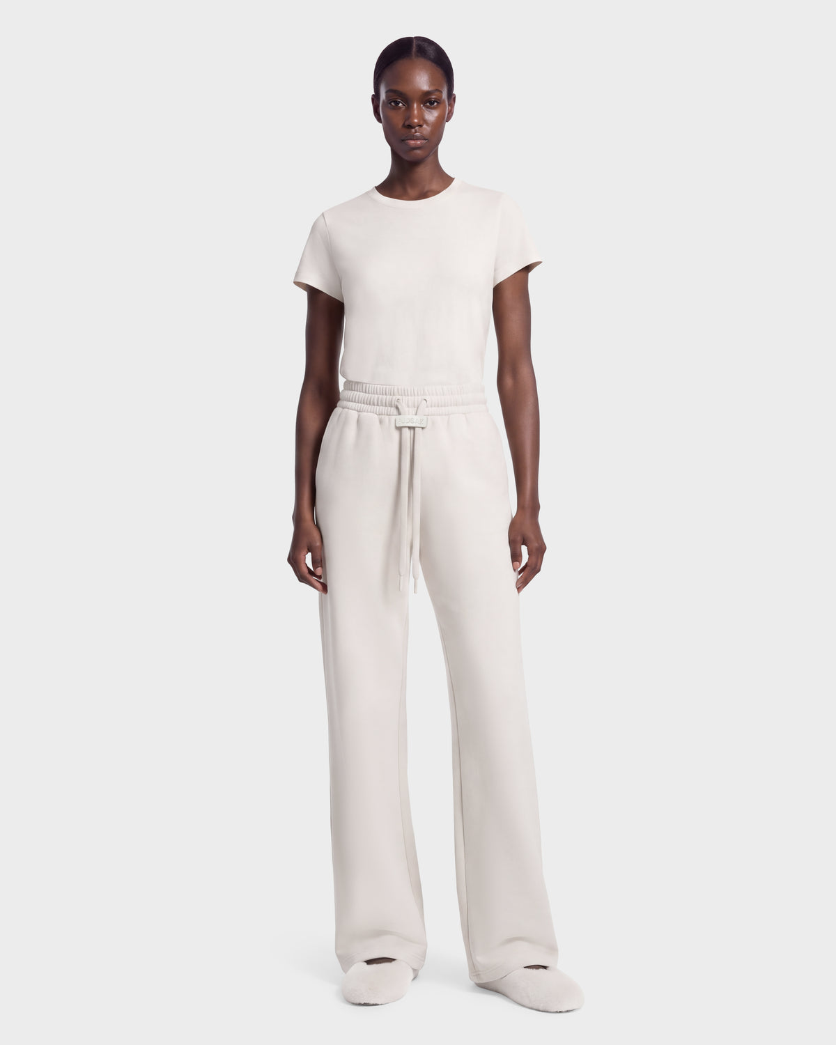A model wearing a vanilla-colored ANGEL - 8526725 short-sleeved t-shirt and matching wide-leg drawstring sweatpants for a refined off-duty look.