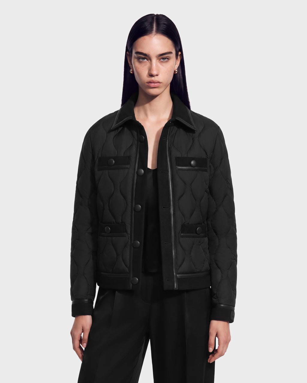 A model wears a black Rudsak JOLIE - 8125036 quilted jacket featuring RDS-certified down, a collared neckline, button-front closure, and four flap pockets.