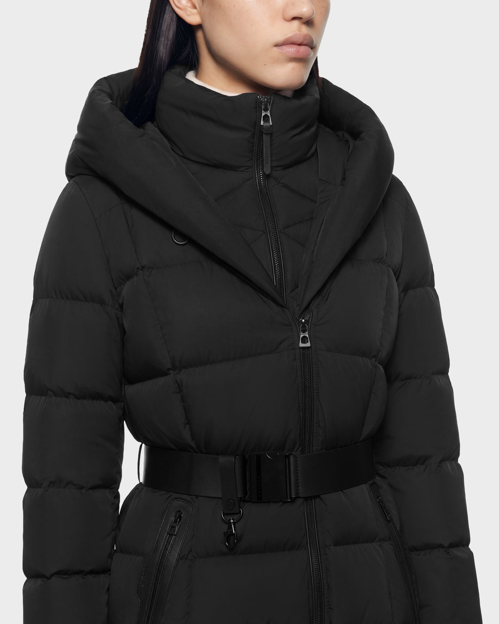 Person wearing a black Rudsak TAYLOR M - 8125965 Black puffer coat with an oversized hood, zippered front, and a buckled waist belt.