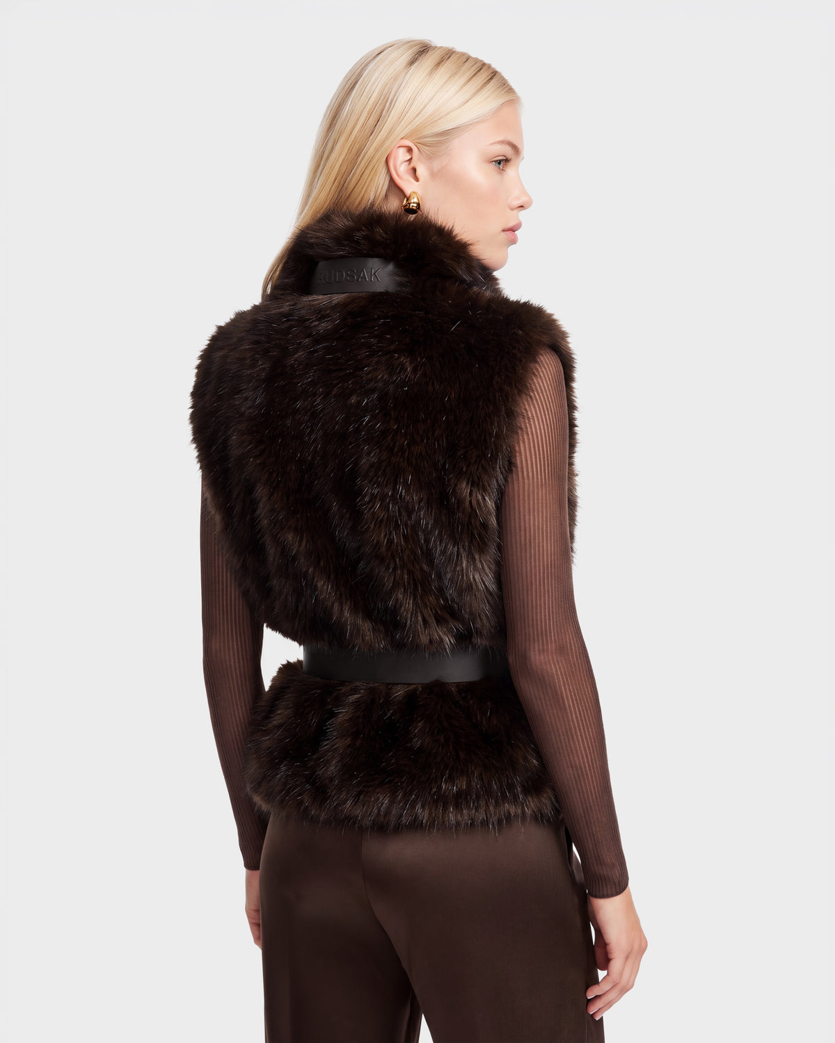 Woman wearing a MAULIN - 8524611 Mix Espresso dark brown faux fur vest over a long-sleeved ribbed mock-neck pullover.