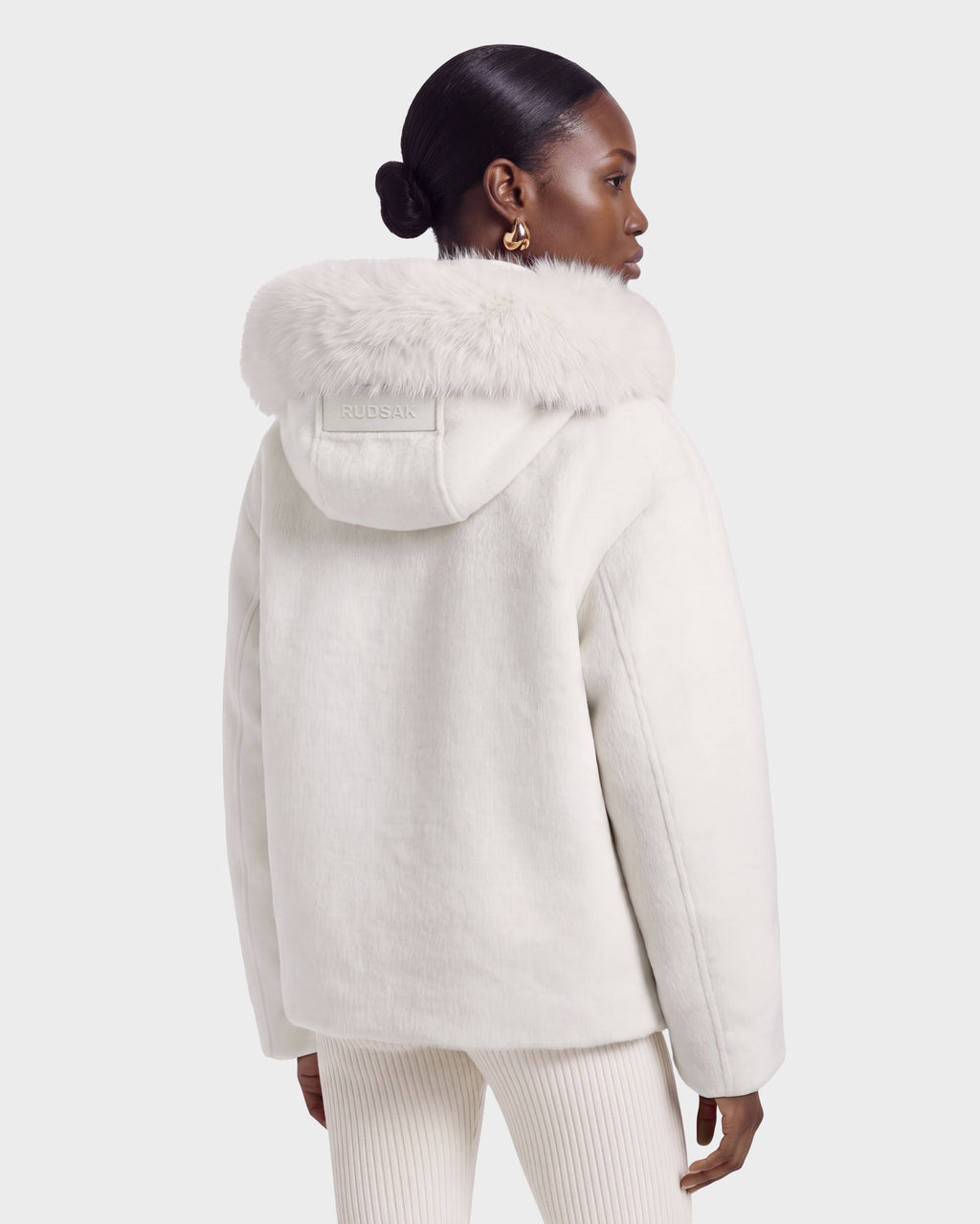 A person seen from the back wearing a cream-colored, textured wool-blend HAZEL - 8126981 Vanilla winter coat with a detachable faux-fur hood.